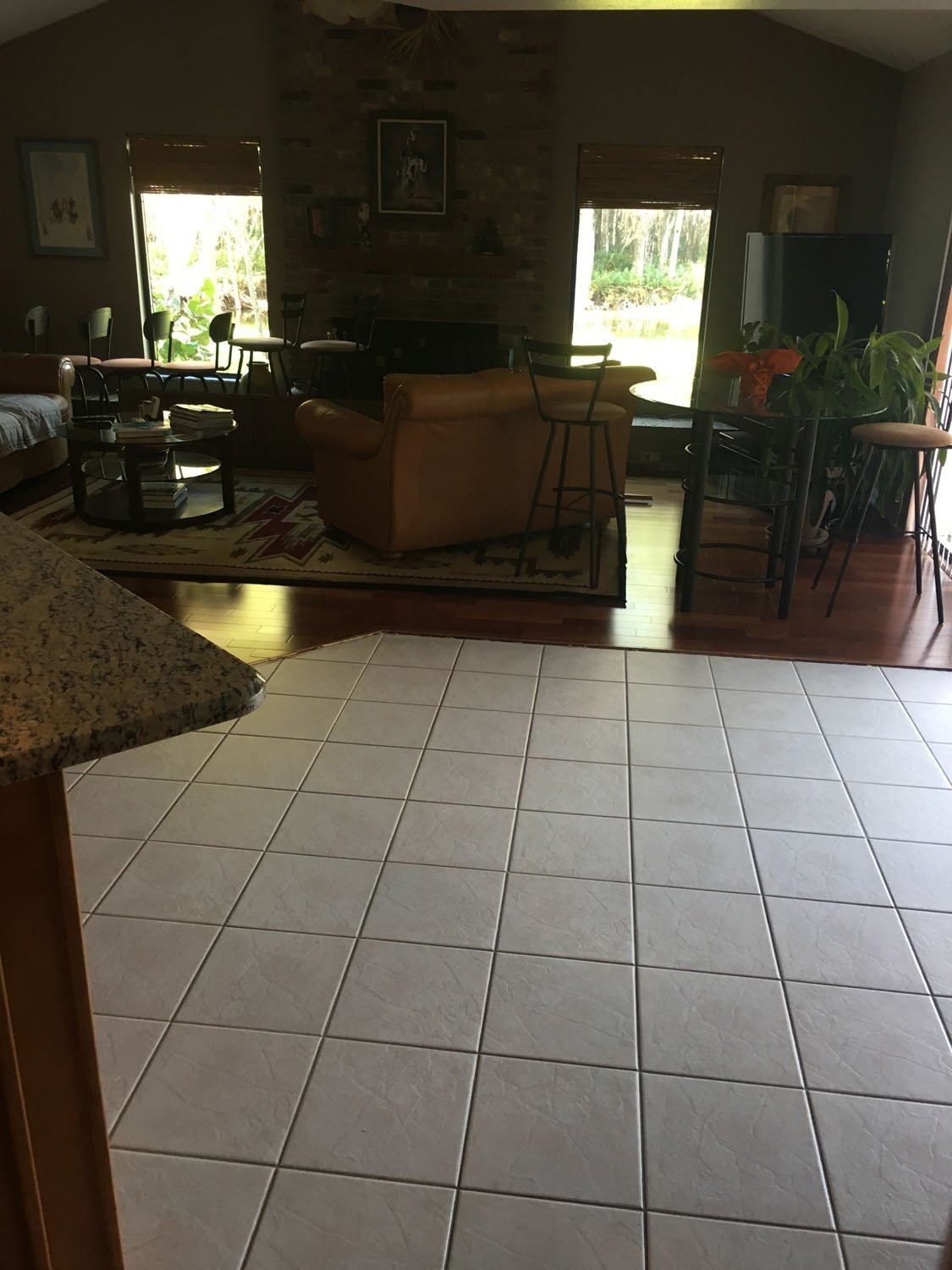A living room with a tiled floor and a fireplace.
