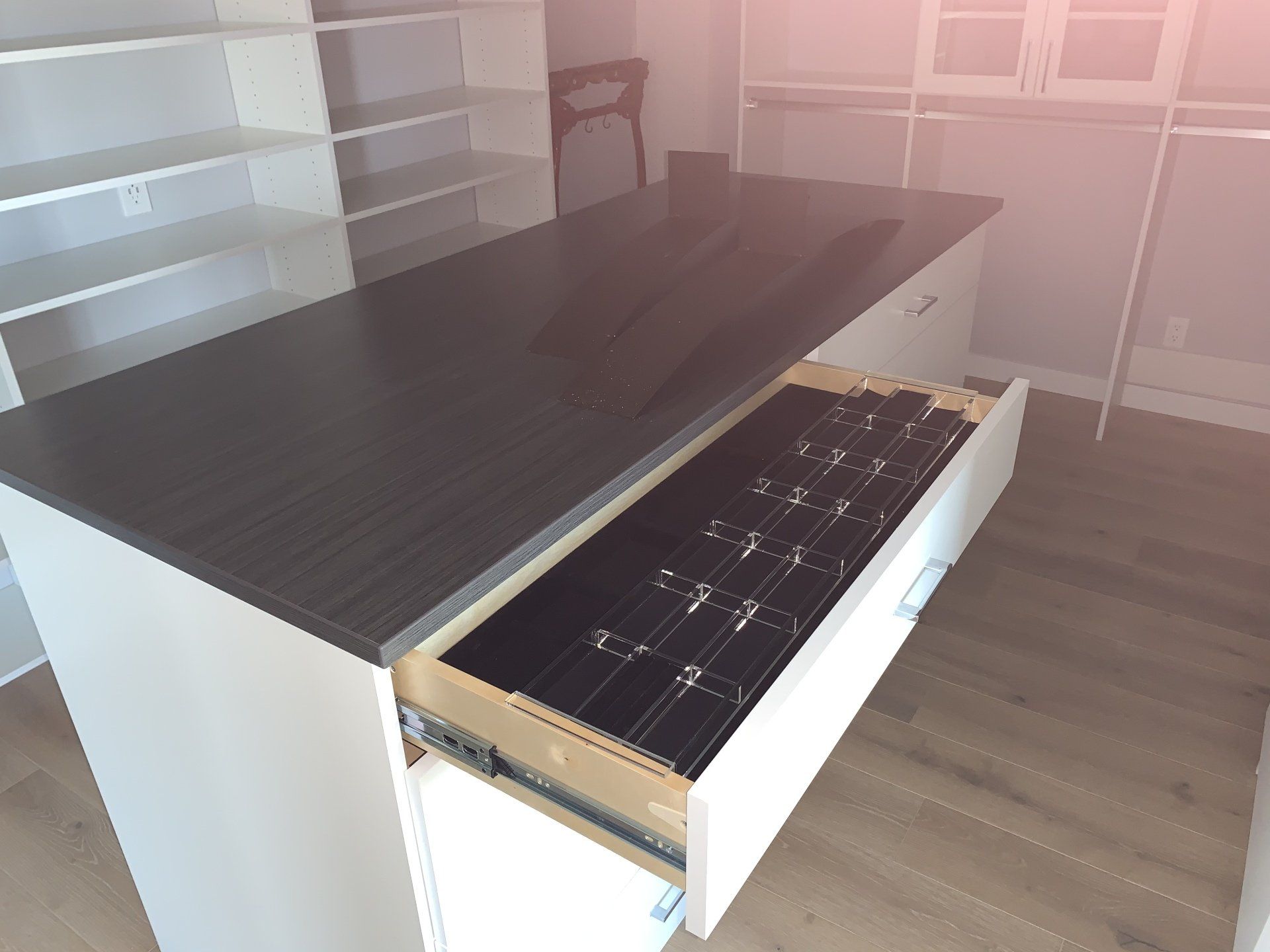 a custom closet cabinet with jewelry tray accessory and a countertop