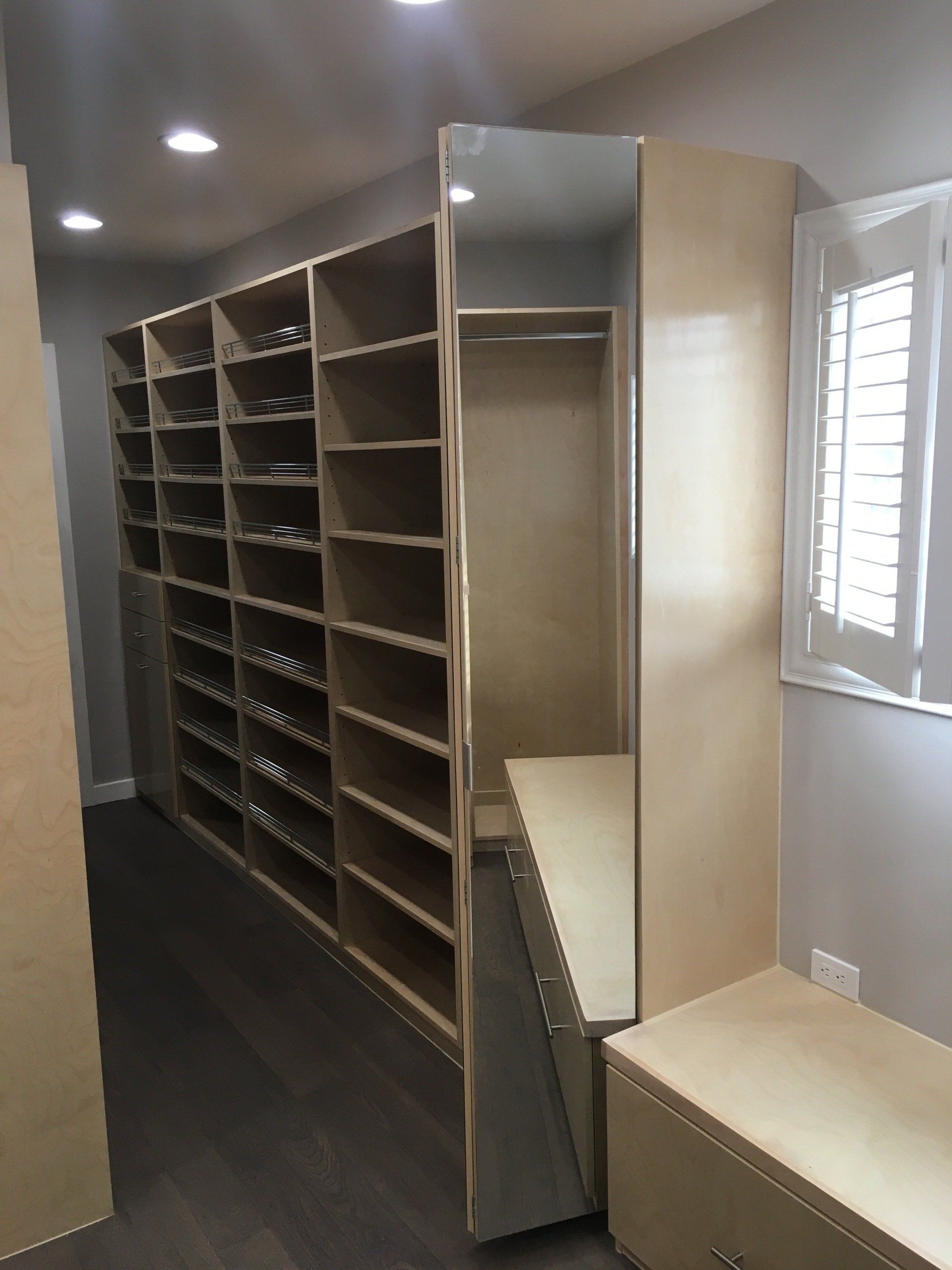 a walk-in closets filled with shoe fences and mirrored door cabinet