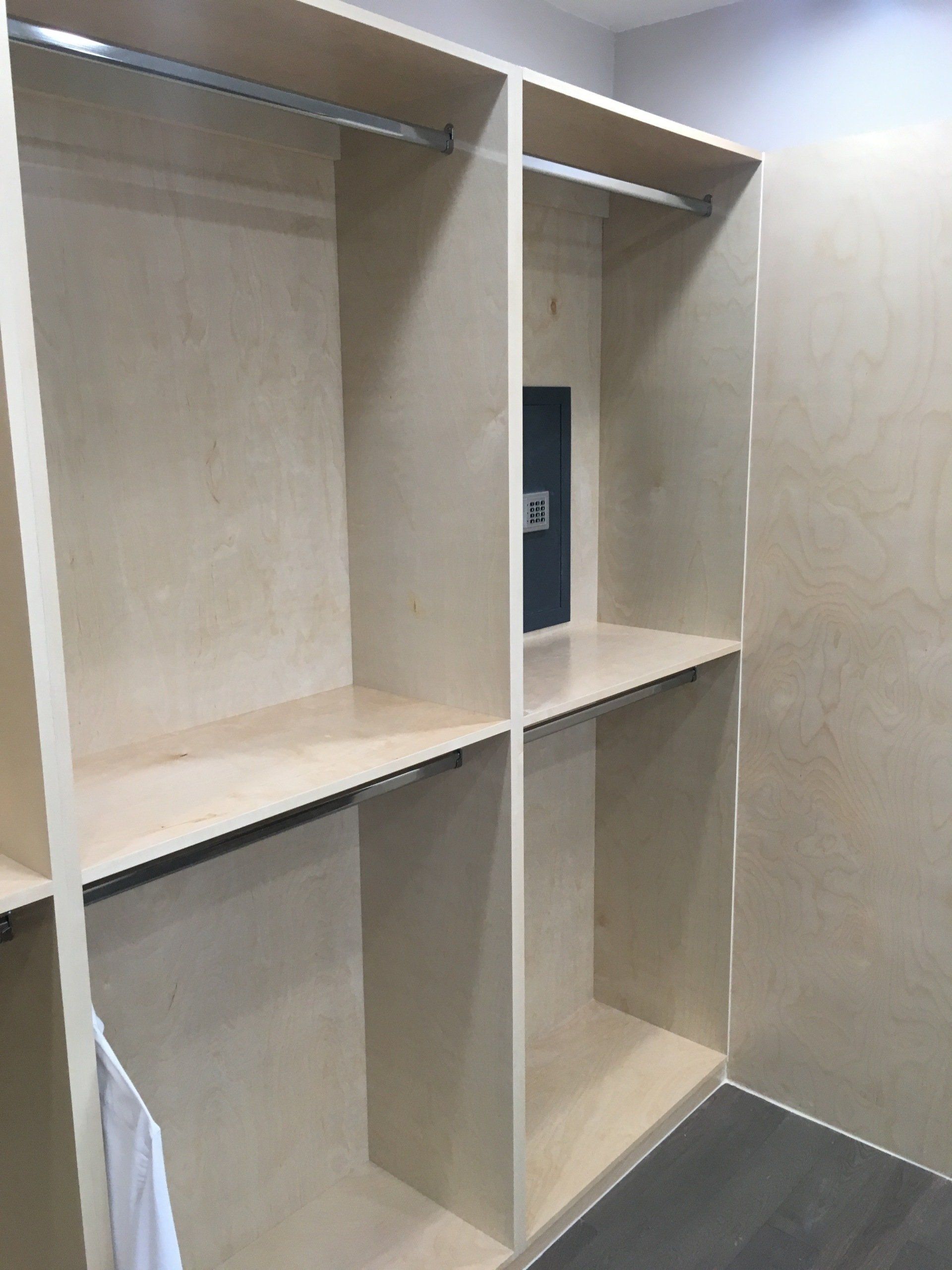 a custom walk in closet filled with hanging rods cabinet