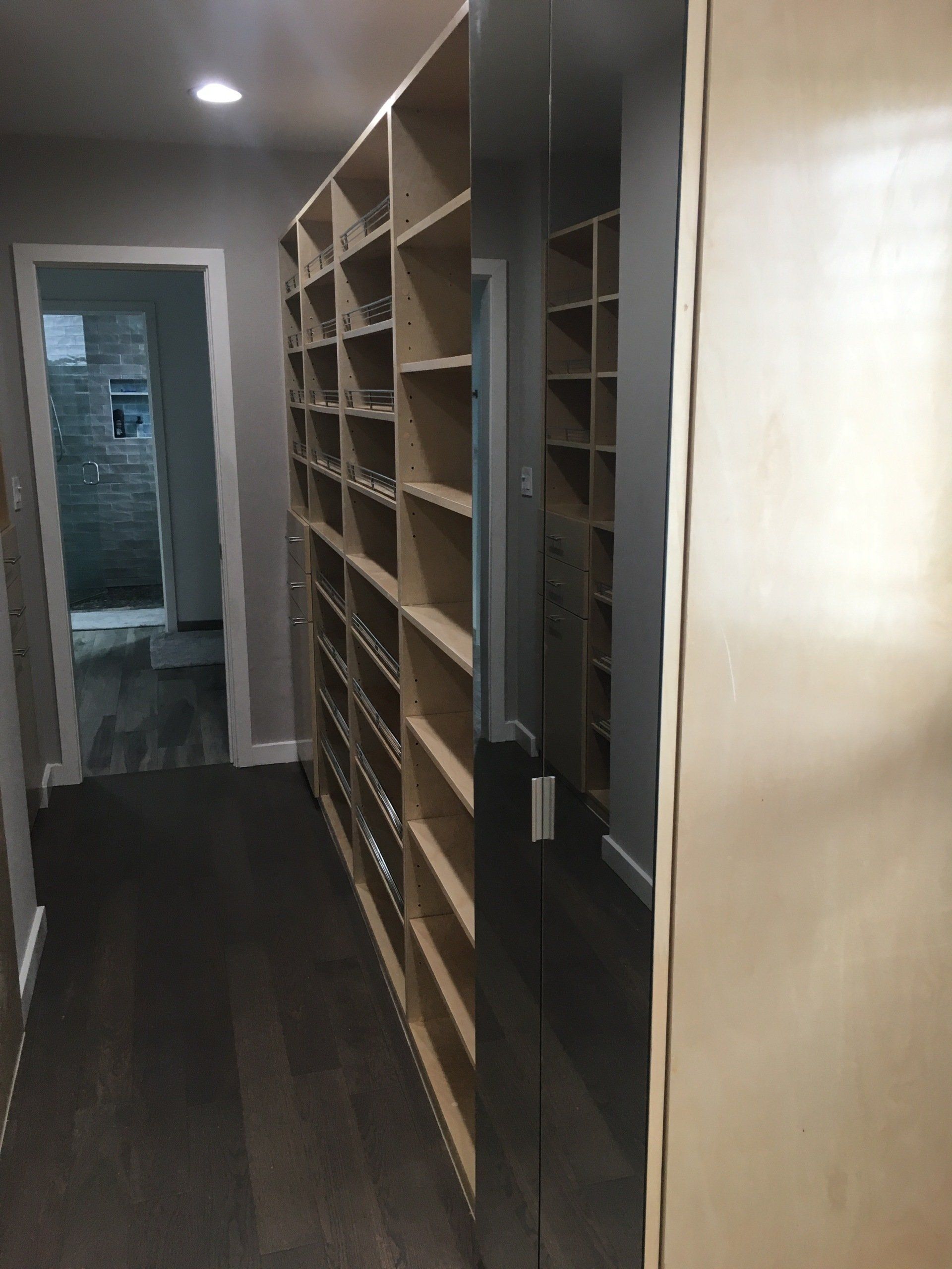 a custom walk-in closet mirrored doors cabinets leading to the bathroom