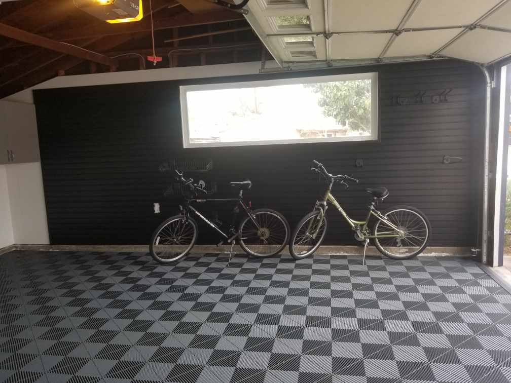 a garage with 2 bikes leaning against  the slatwall
