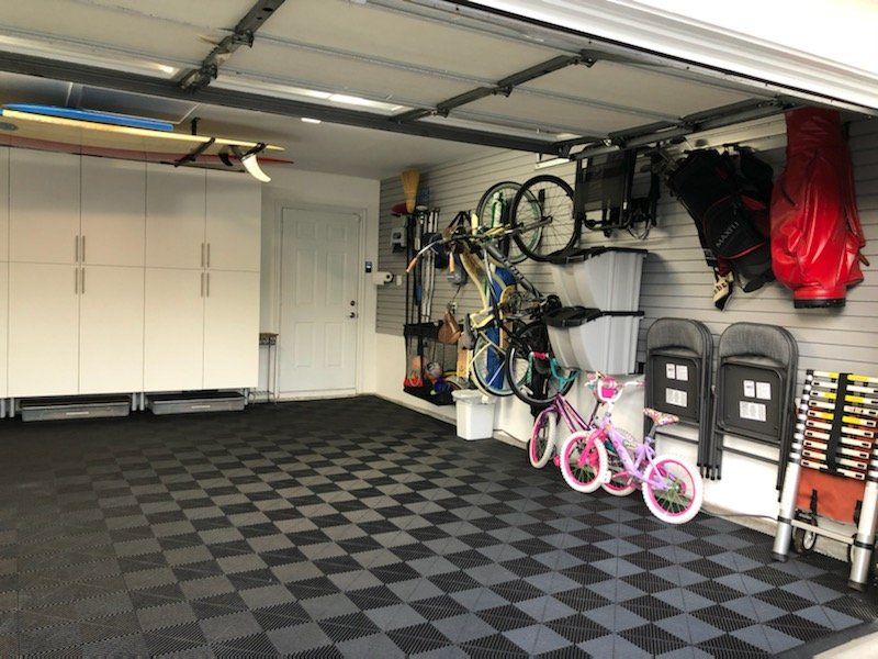  a garage with a bicycle rack, dual bins and a Swisstrax floor