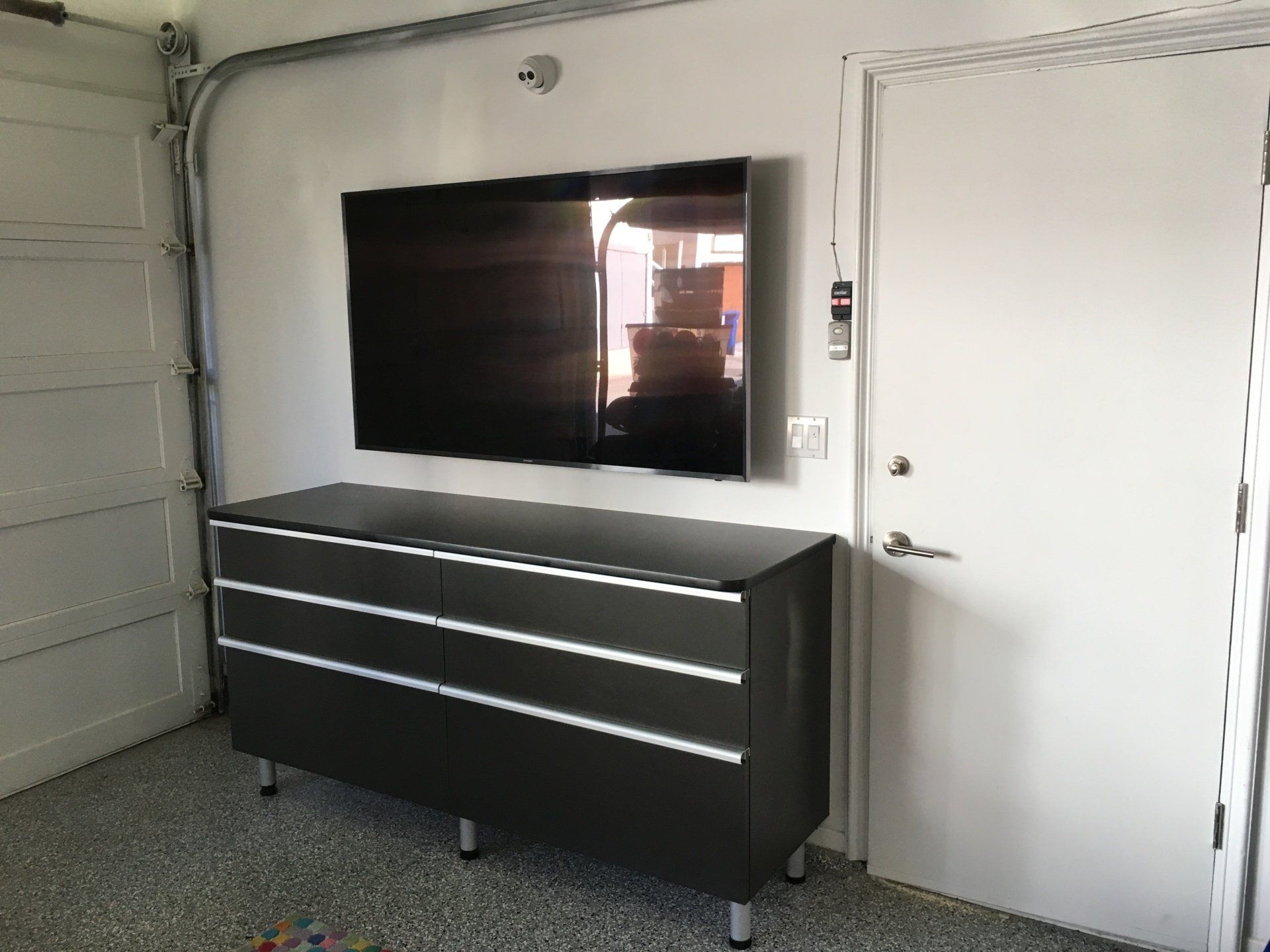 a garage workbench cabinet with flatscreen tv on top
