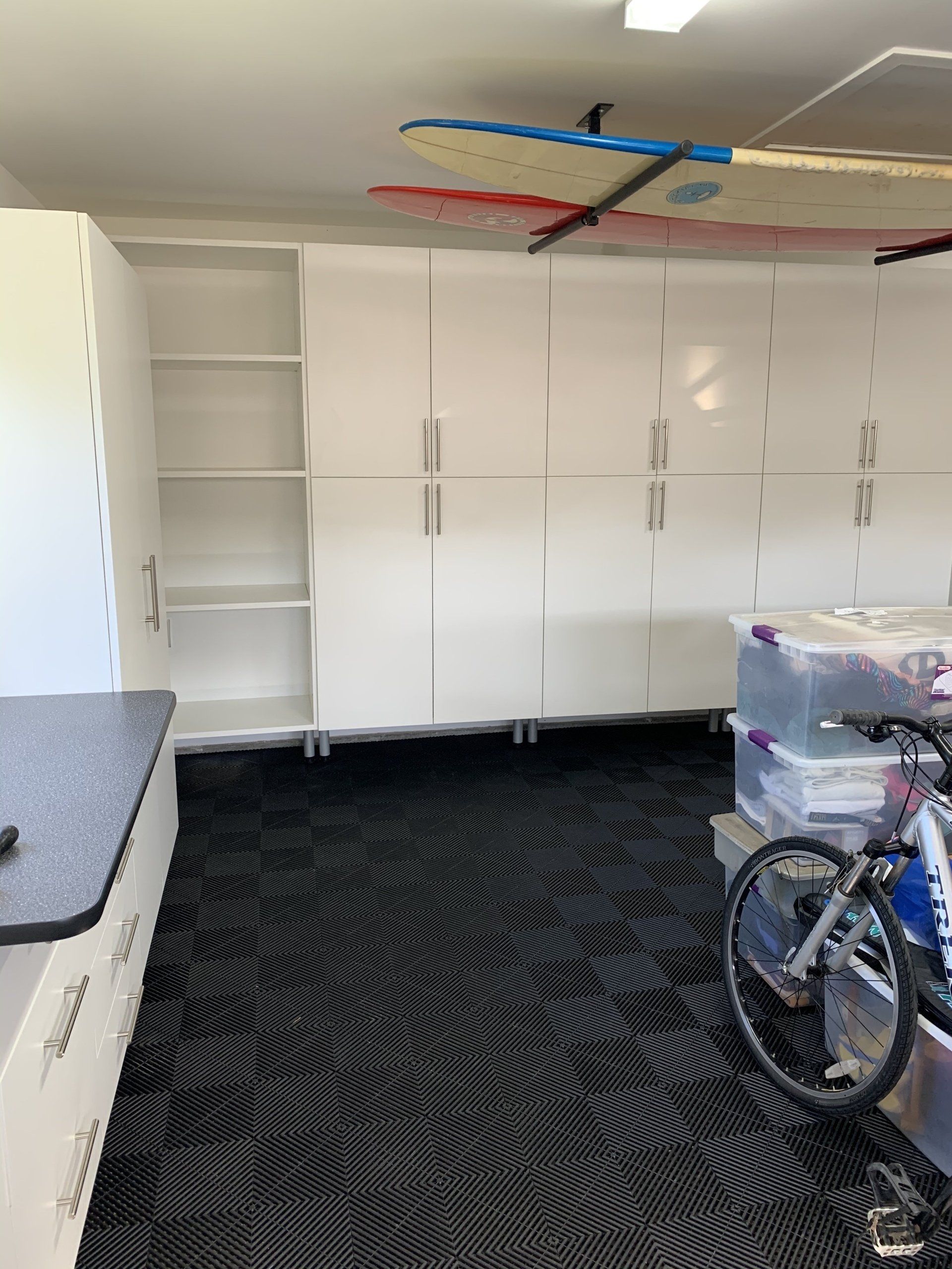 a white garage cabinet system with shelves 
