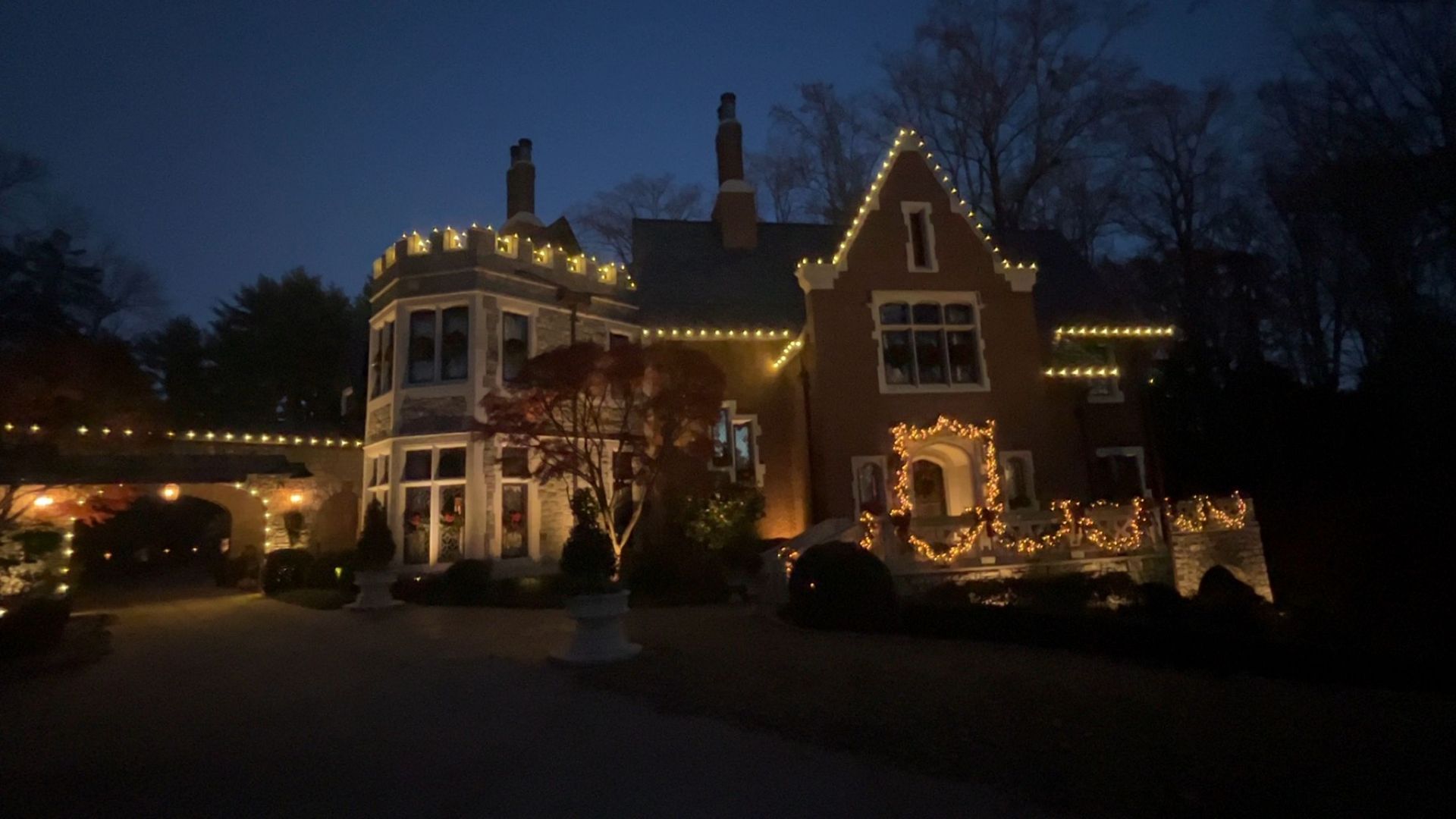 A house decorated with christmas lights is lit up at night