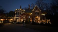 A house decorated with christmas lights is lit up at night