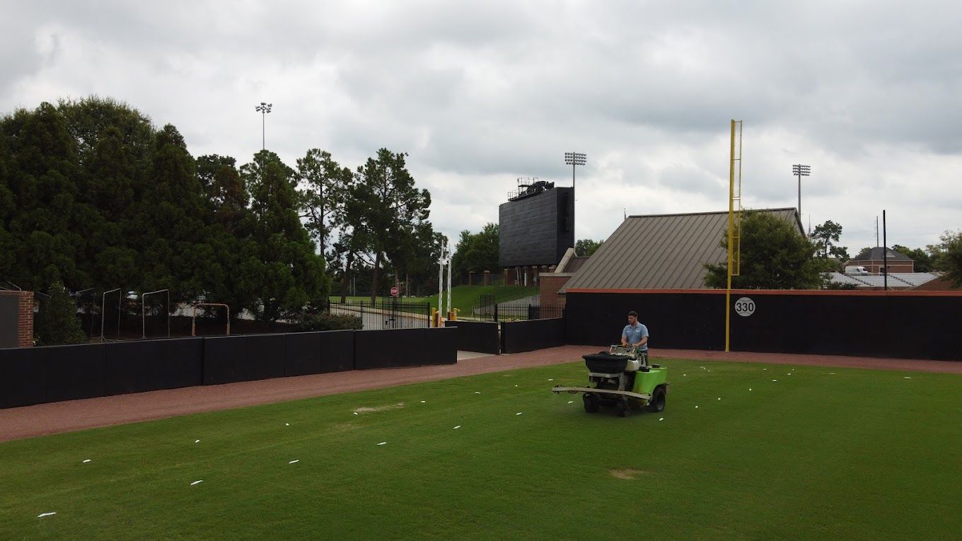 Turf Magic technician applying treatment to Mercer University’s baseball turf