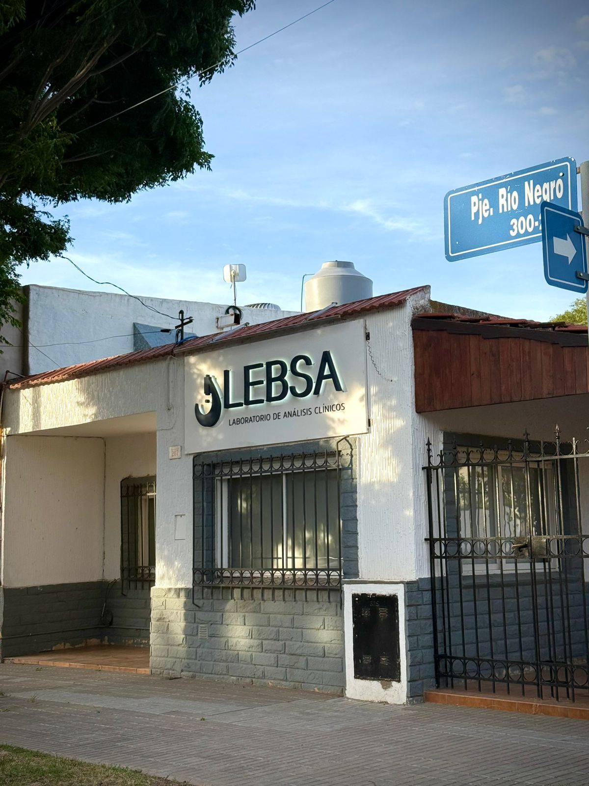 Cartel con el texto “SOCIAL WORKS SALUD ACCESIBLE”, viales de sangre y el logotipo de LEBSA.