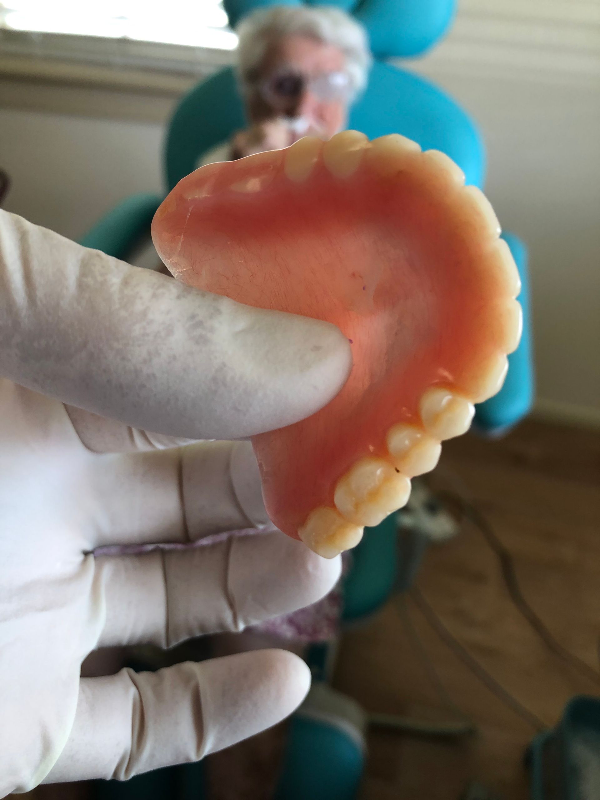 Gloved Hand Holds a Set of Upper Dentures — My Denture Clinic in Tamworth, NSW