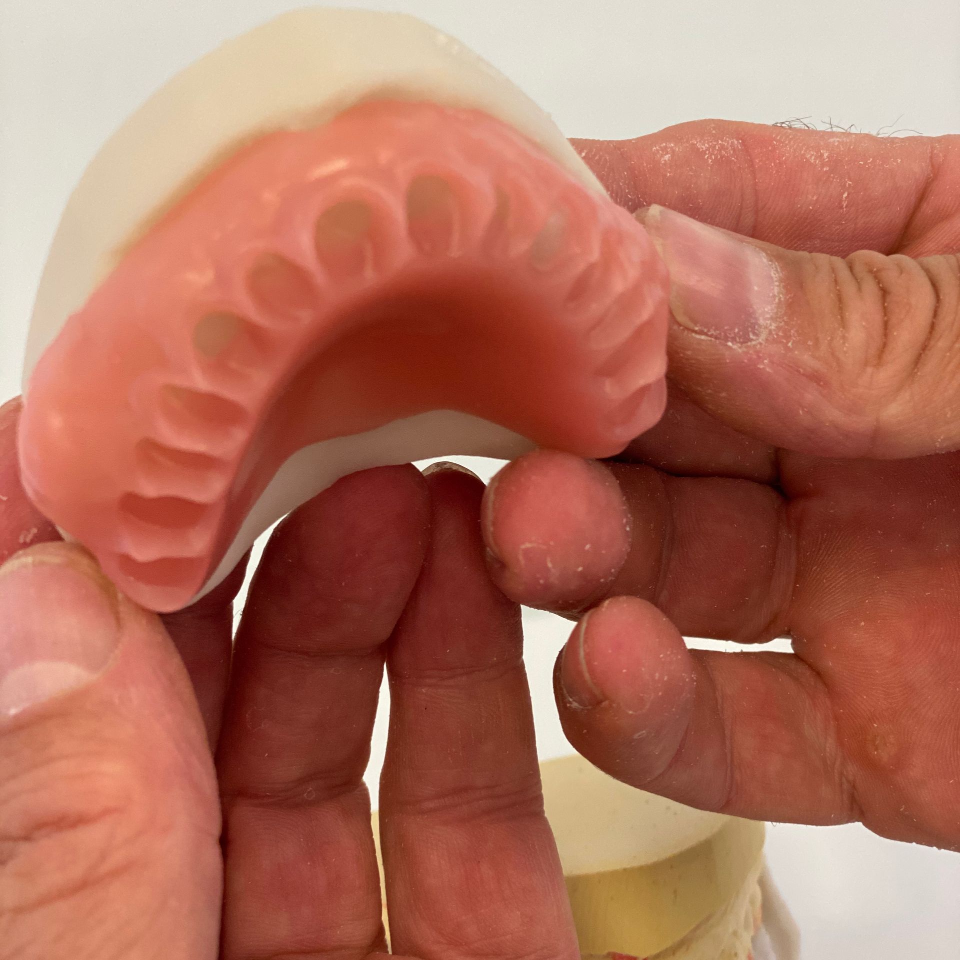 Hands Holding a Pink and White Dental Mold — My Denture Clinic in Gold Coast, QLD