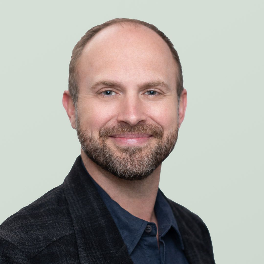 A bald man with a beard is smiling for the camera.