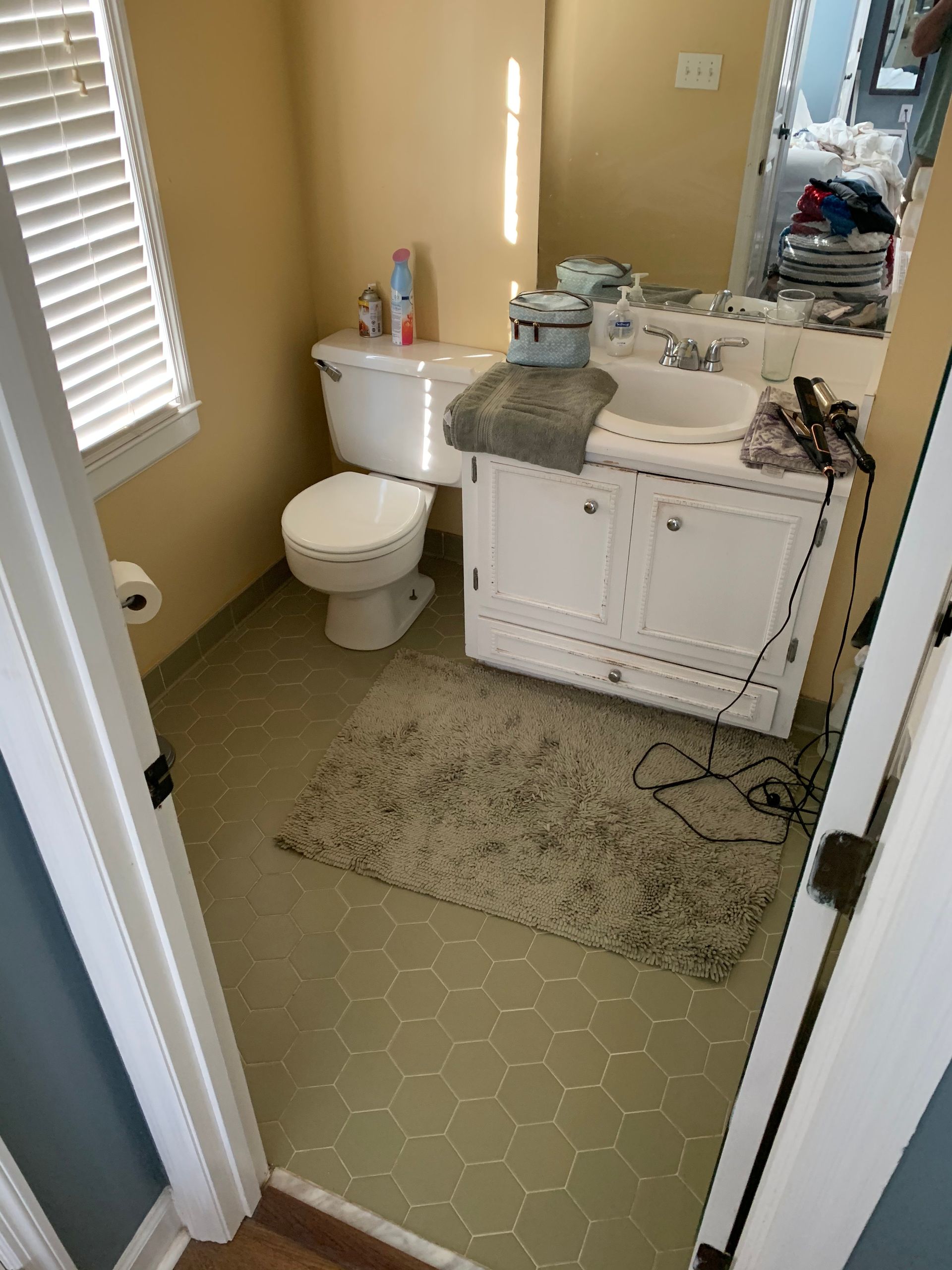 A bathroom with a toilet , sink , and mirror.