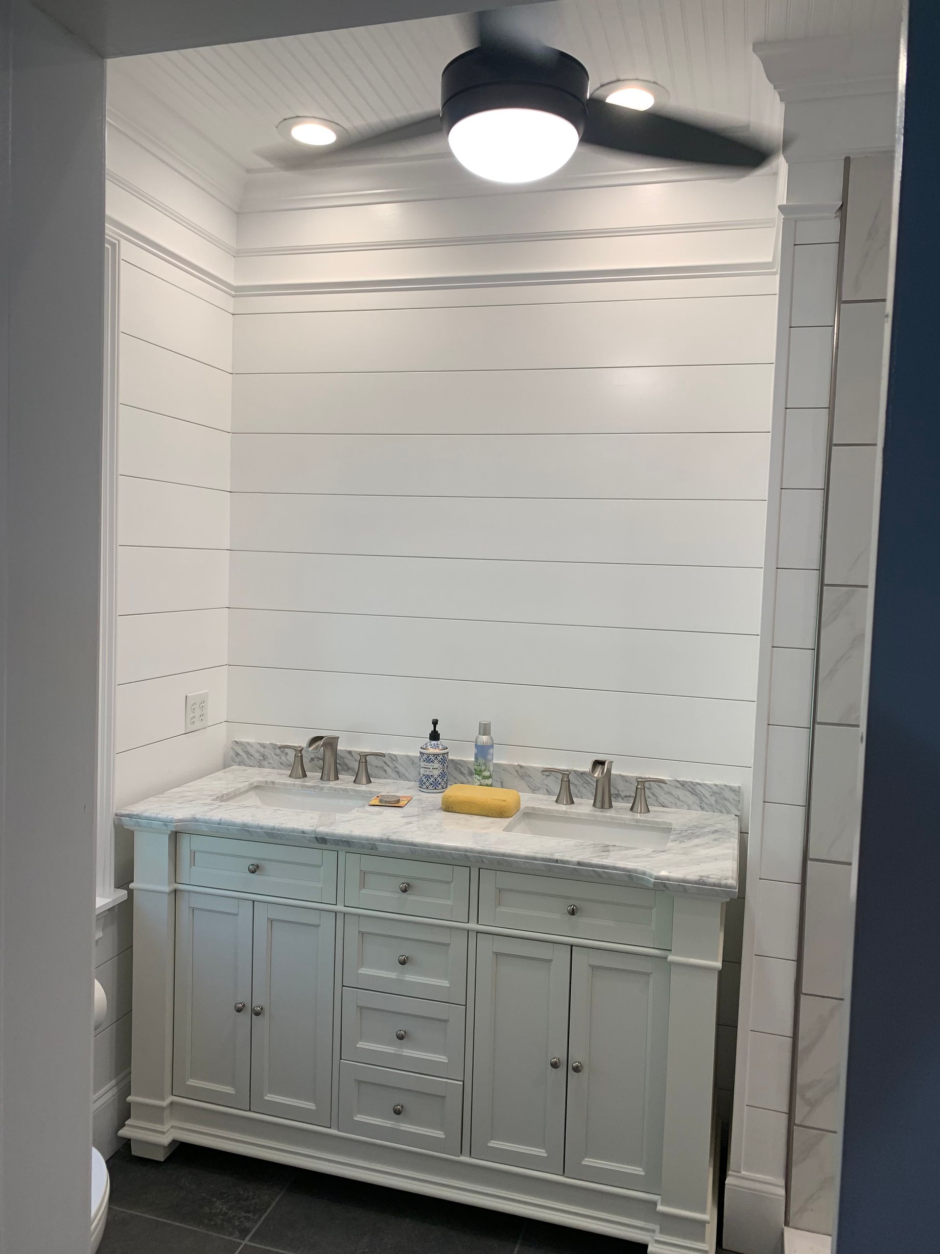 A bathroom with two sinks and a ceiling fan.