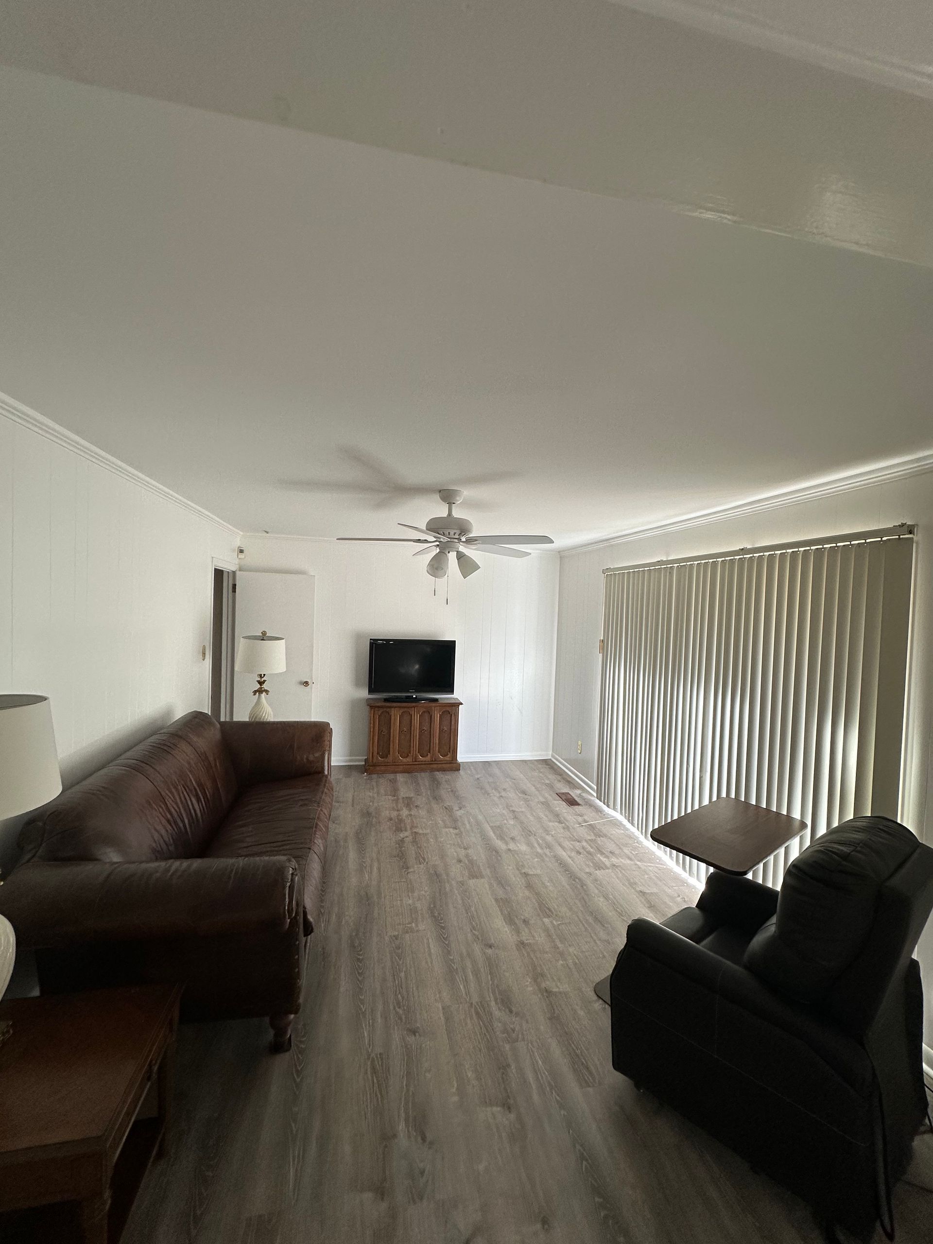 A living room with a couch , chair , table and television.