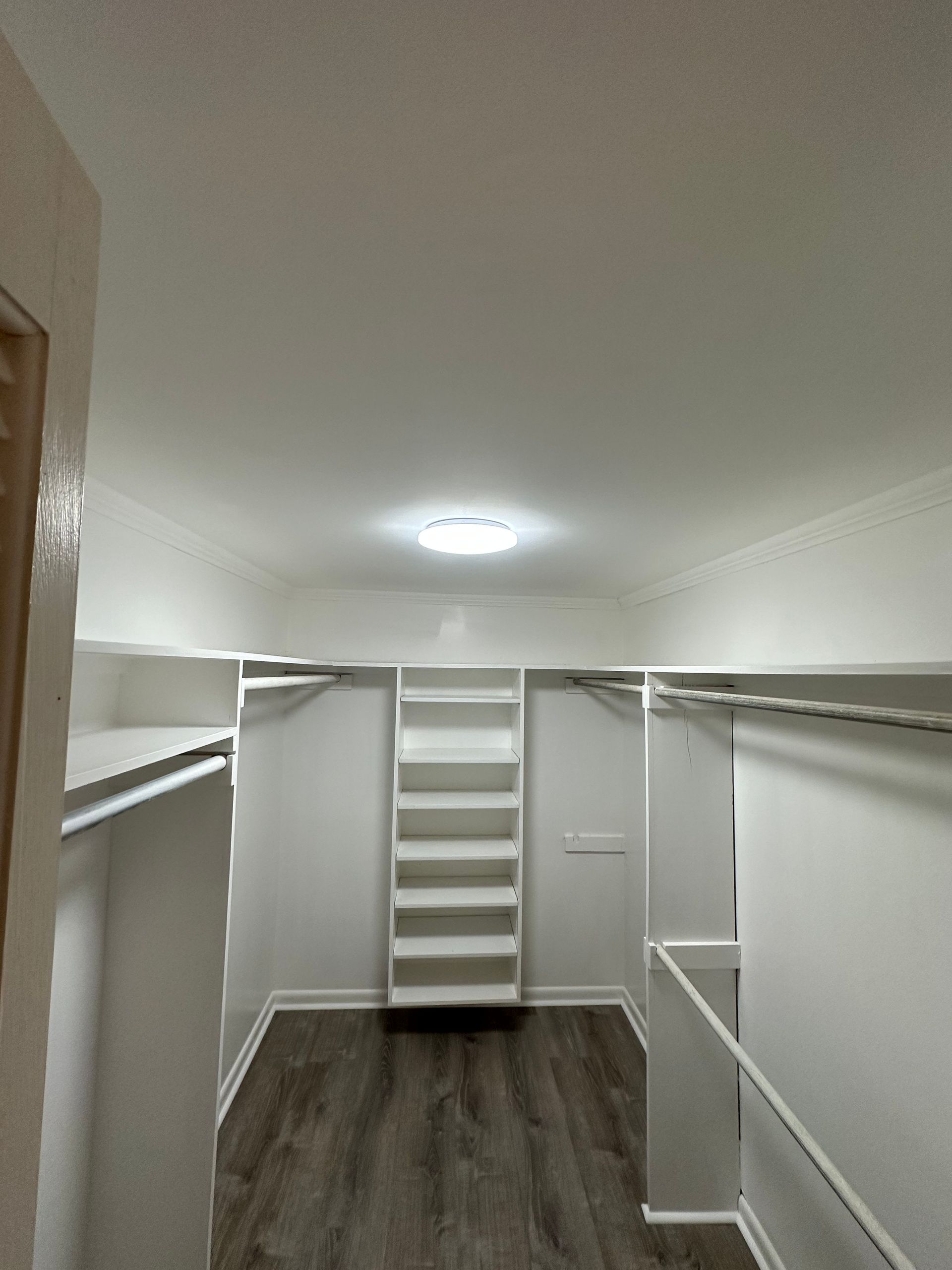 A walk in closet with a staircase and lots of shelves