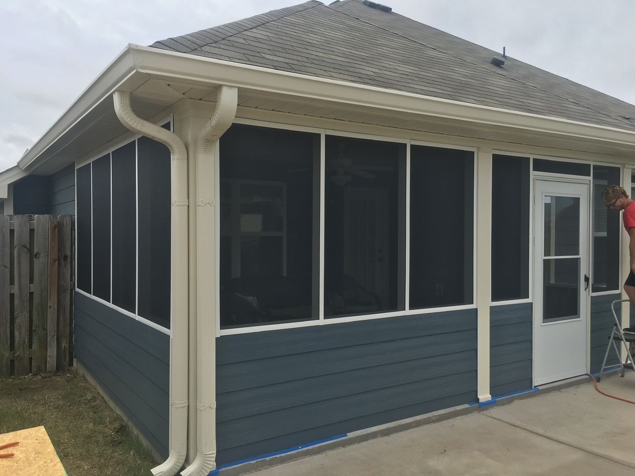 A screened in porch on the side of a house