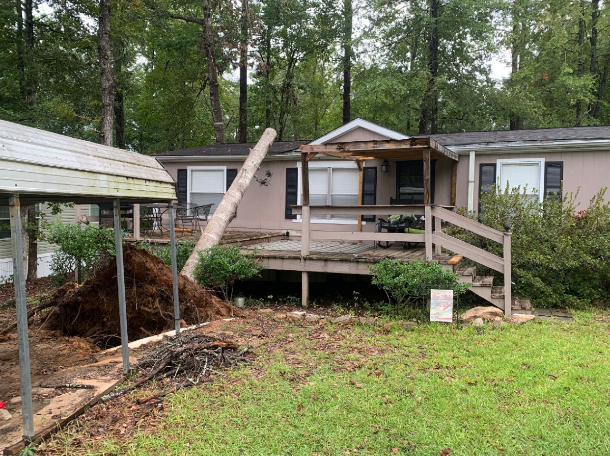 A mobile home with a broken deck and stairs.