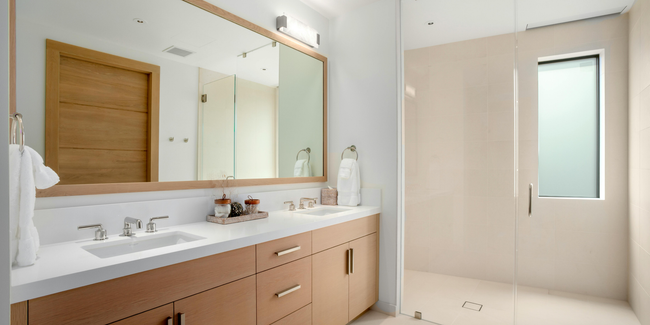 Electrician in overalls and cap inspecting a circuit breaker panel.