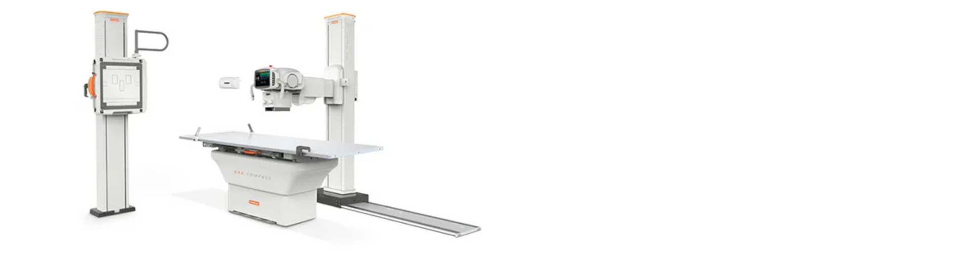 Medical X-ray machine in a white room. The X-ray head is positioned over a patient bed.