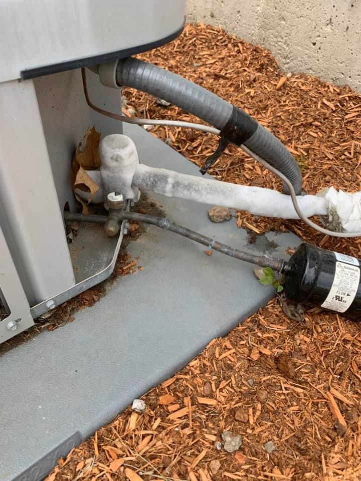 A close up of an air conditioner with a hose attached to it.
