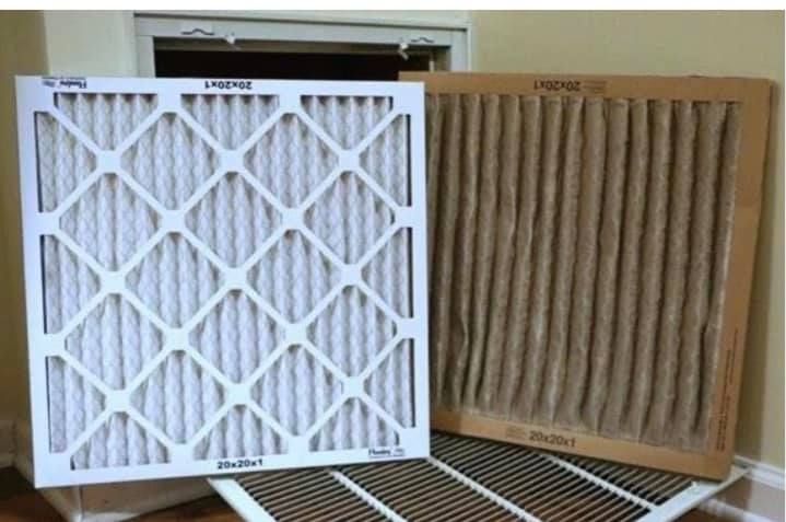 Two filters are sitting next to each other on a wooden floor.