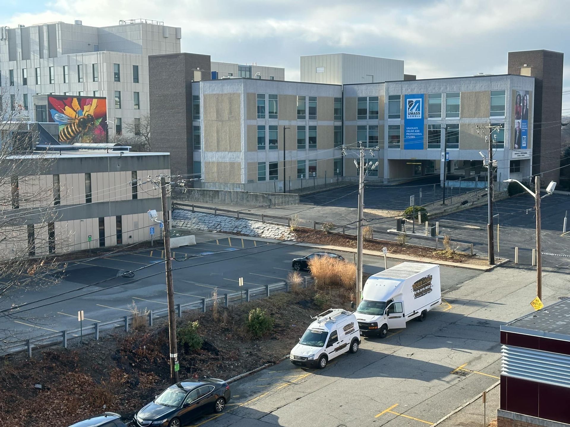 An aerial view of a parking lot with a large building in the background