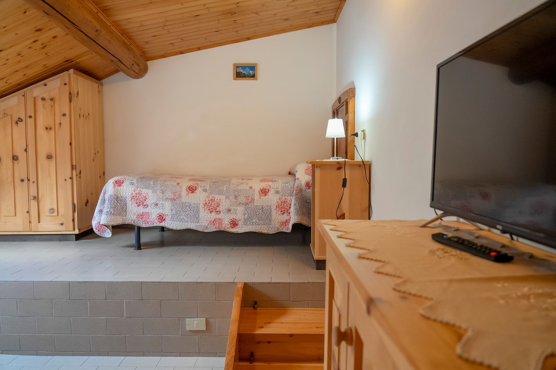 Una camera da letto con un letto e una tv a schermo piatto.