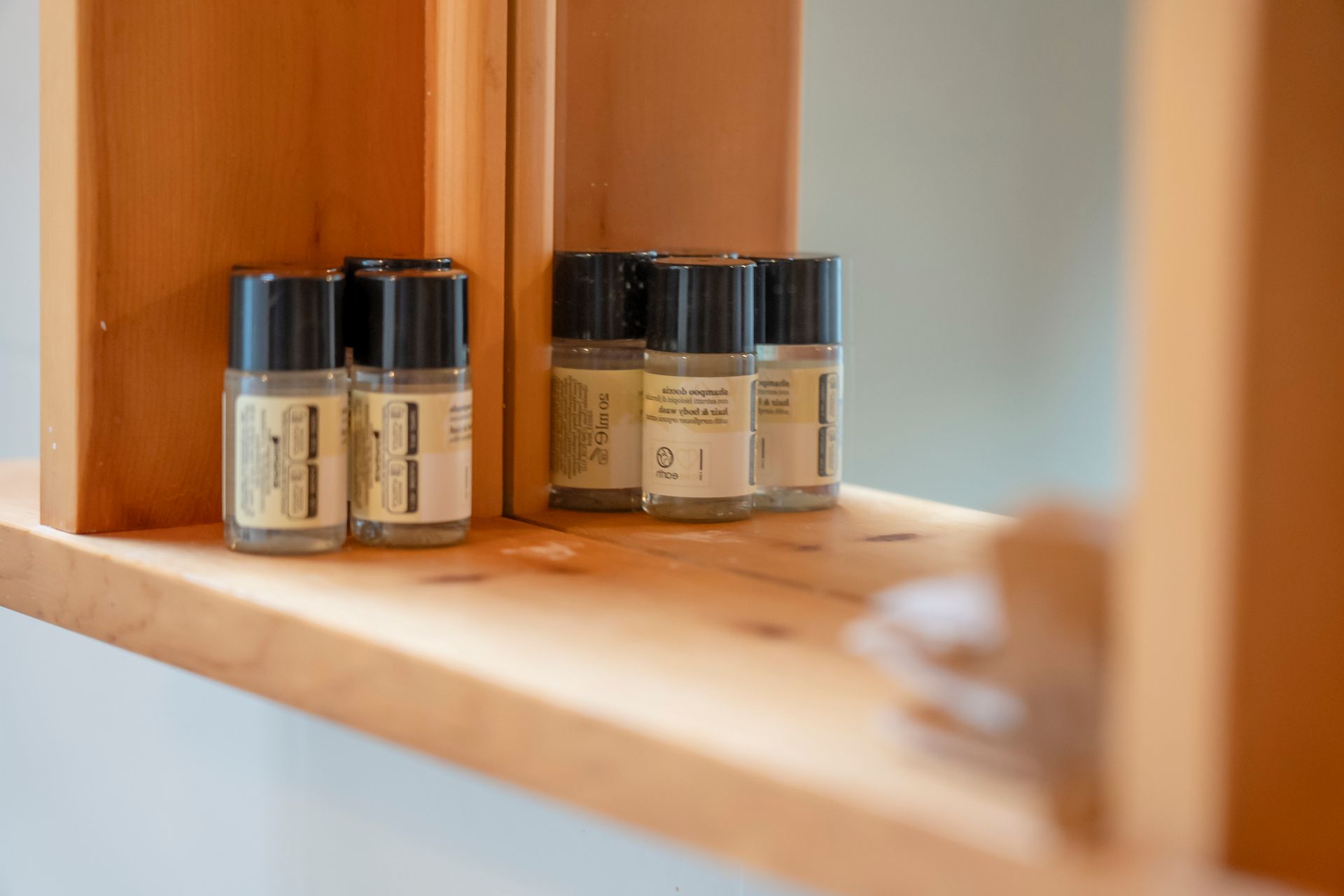 Uno scaffale di legno con sopra delle bottiglie di oli essenziali.