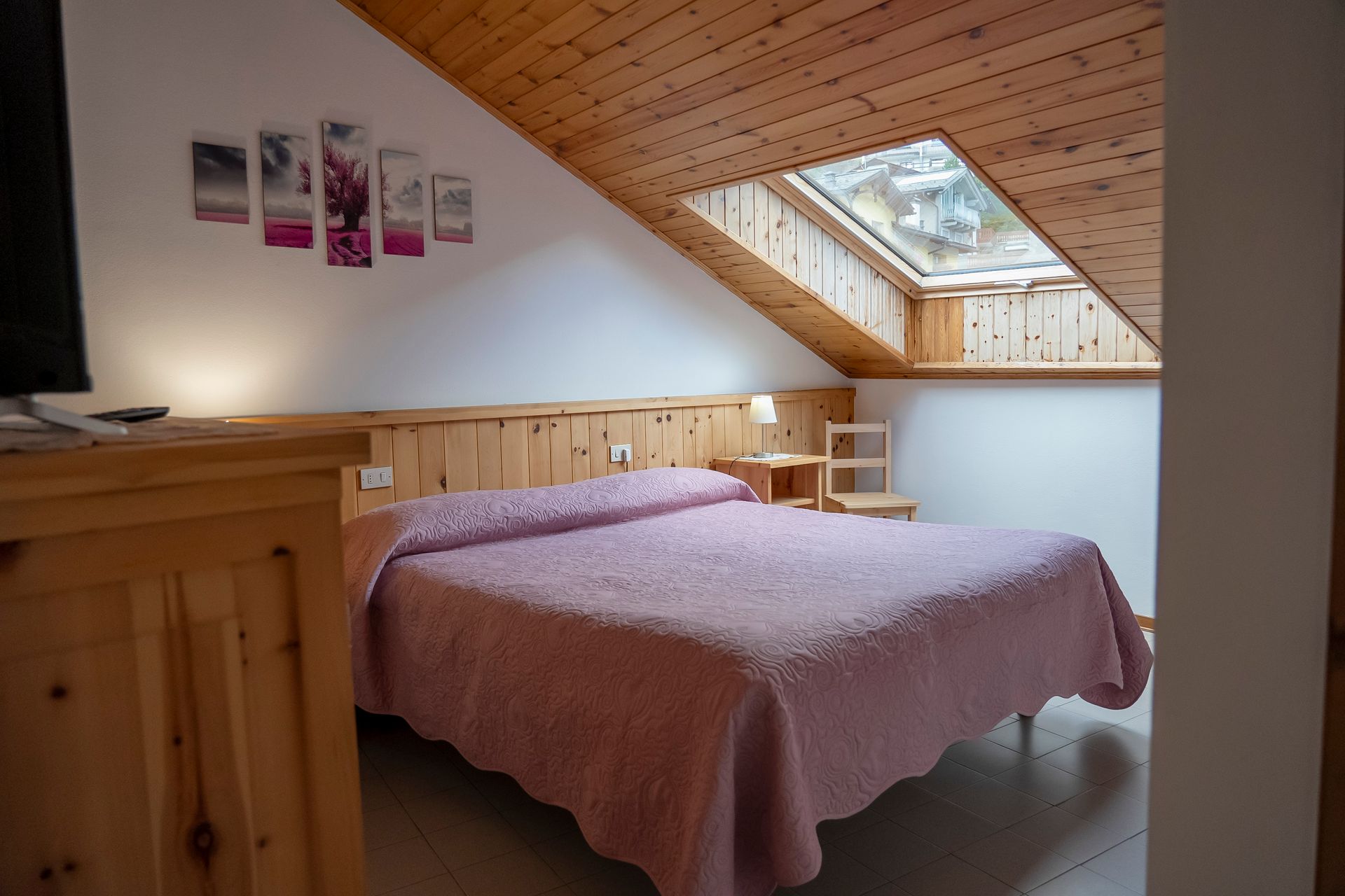 Una camera da letto con un letto king size e un lucernario