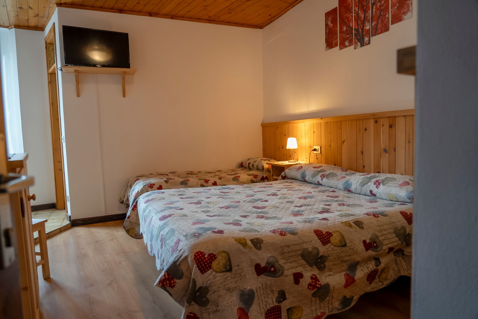 Una camera da letto con due letti e una tv a schermo piatto.