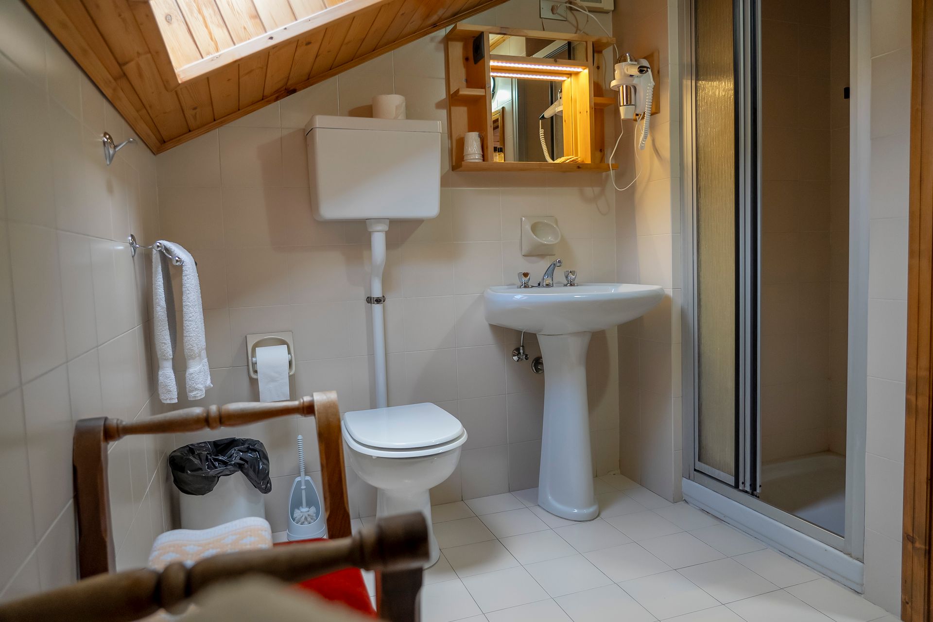 Un bagno con wc, lavandino, doccia e specchio.