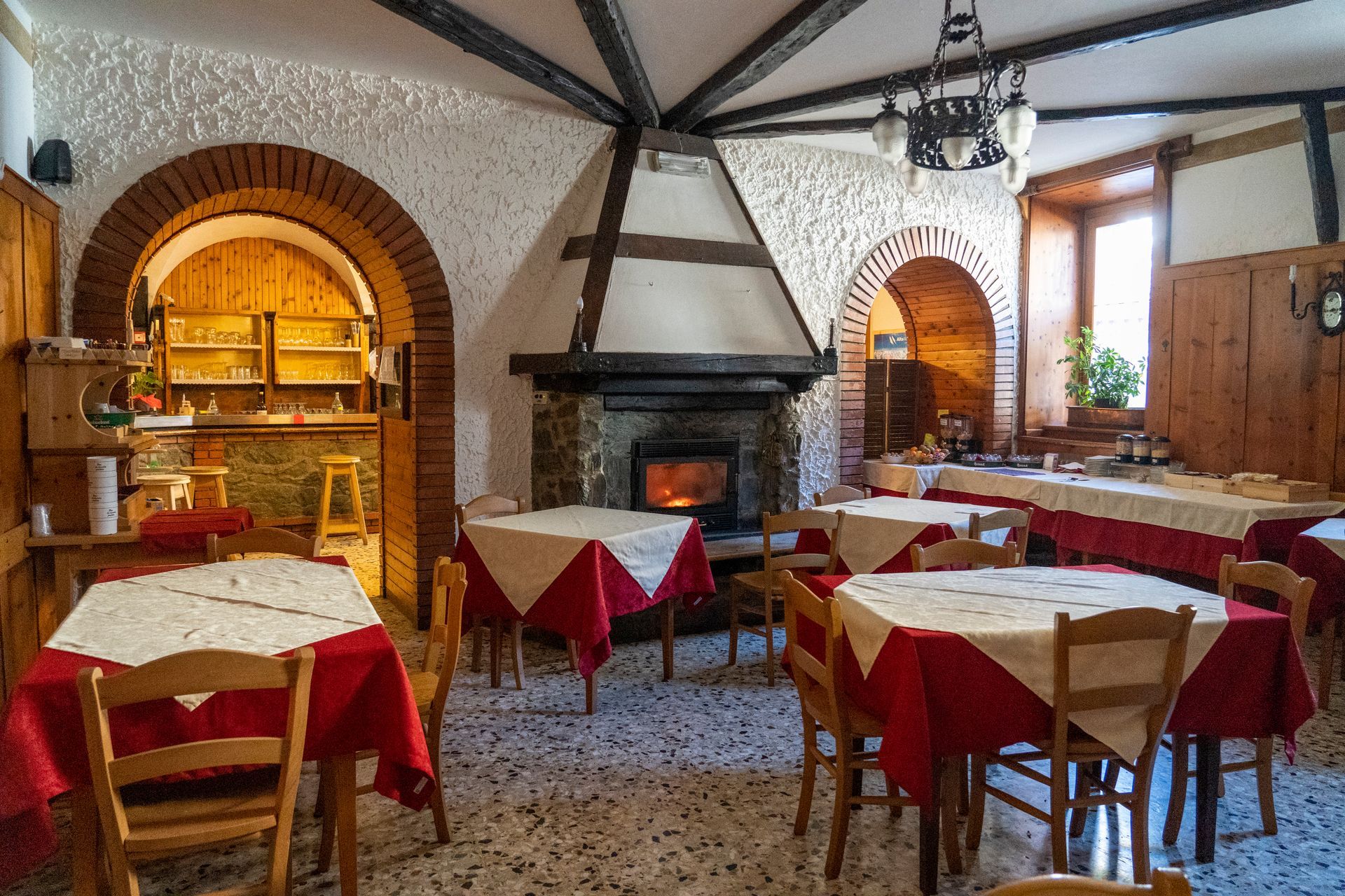 Un lungo tavolo con una tovaglia rossa in un ristorante