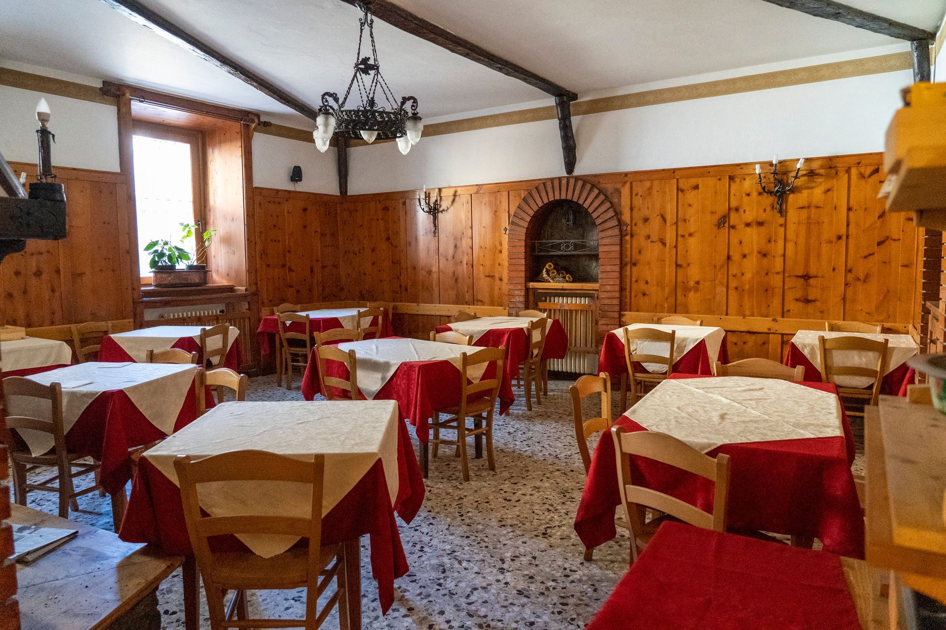 Un ristorante con tavoli, sedie e un lampadario.