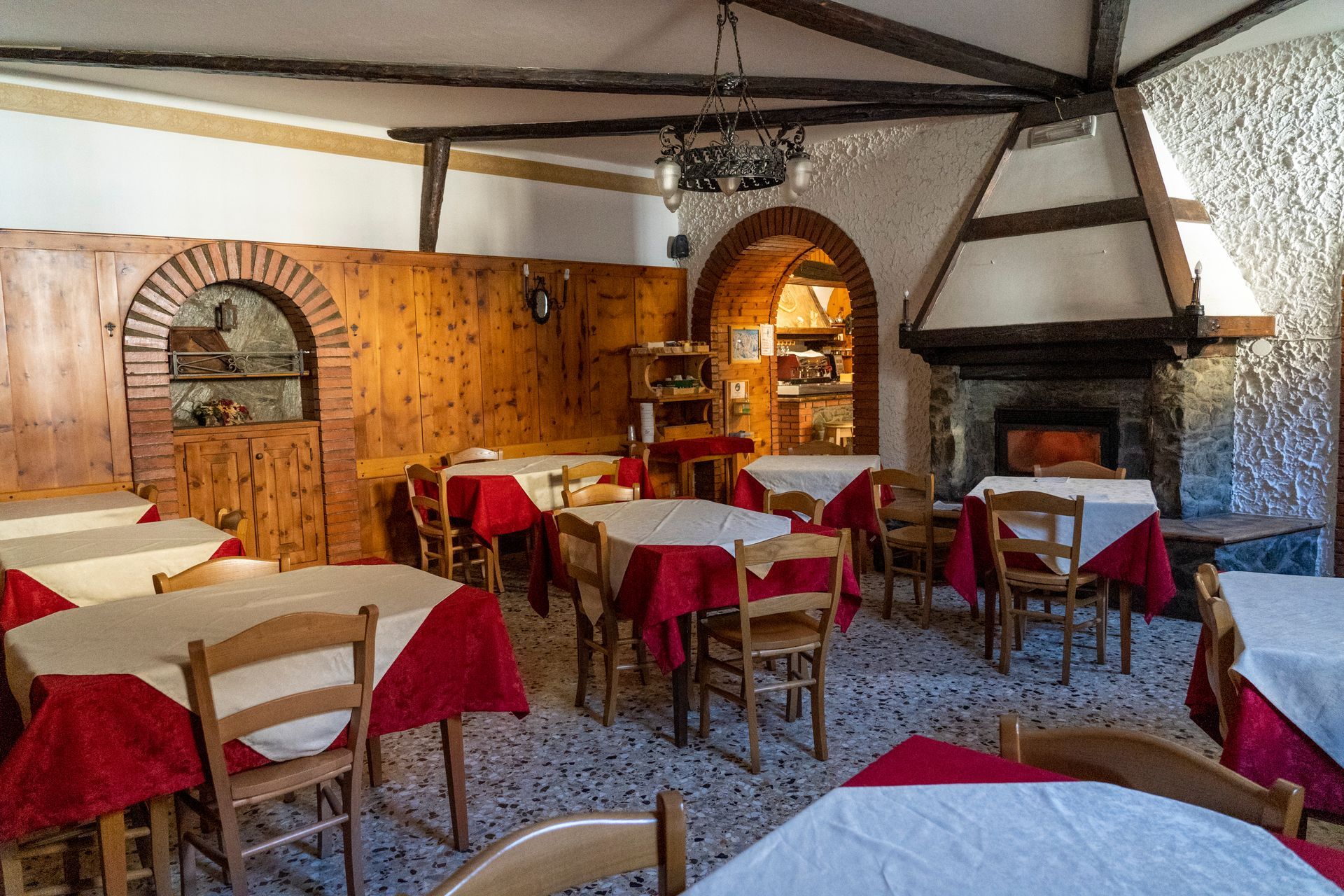 Un ristorante con tavoli, sedie e un camino.