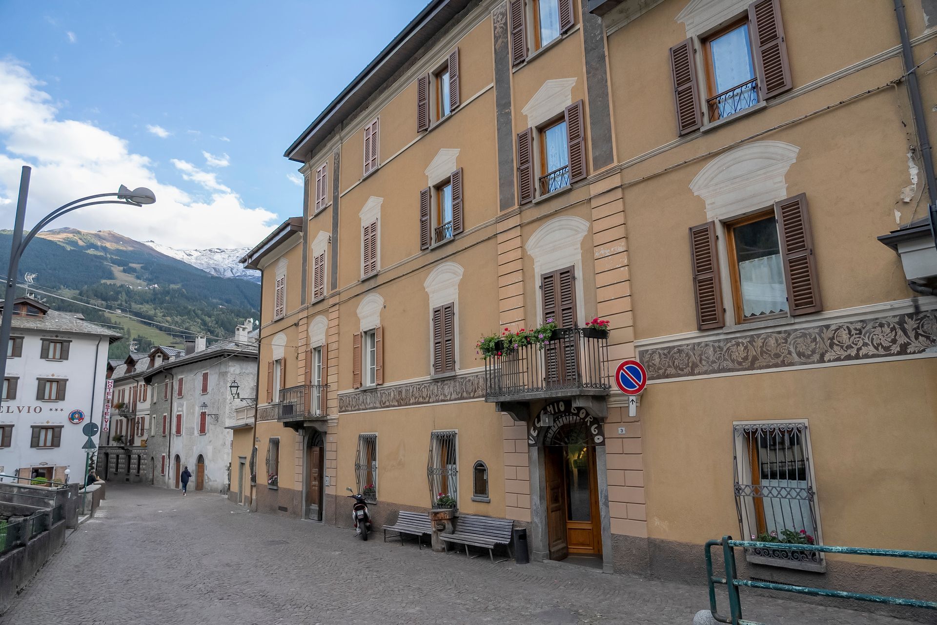 Un grande edificio con un cartello di divieto di sosta davanti.