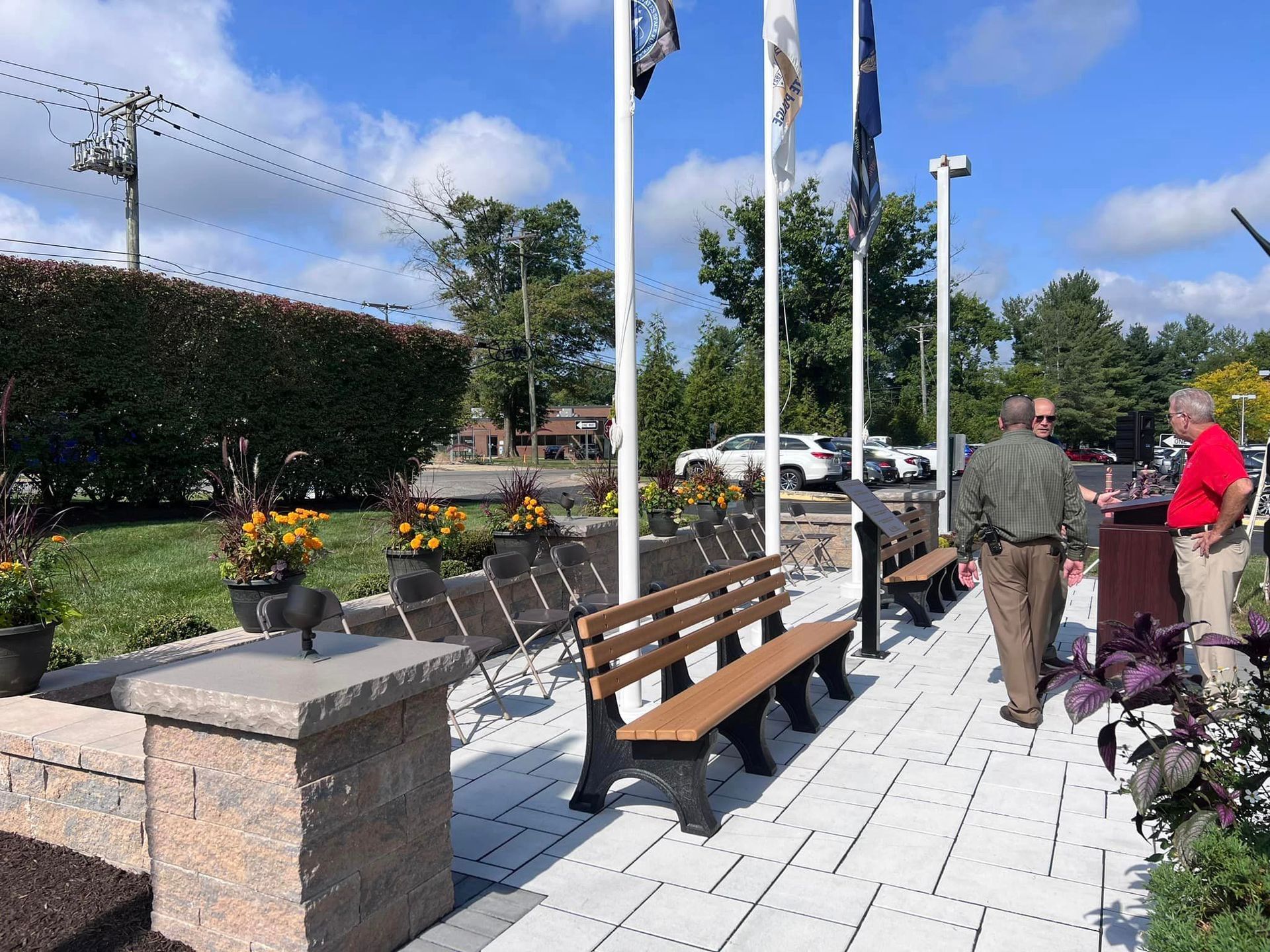 A man in a red shirt is standing next to a bench