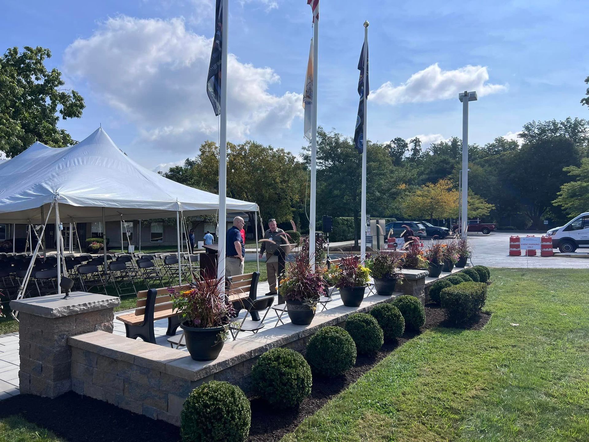 A white tent is sitting in the middle of a lush green field.