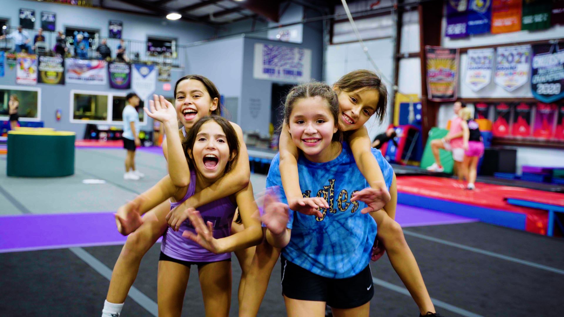 A group of young girls are posing for a picture in a gym.