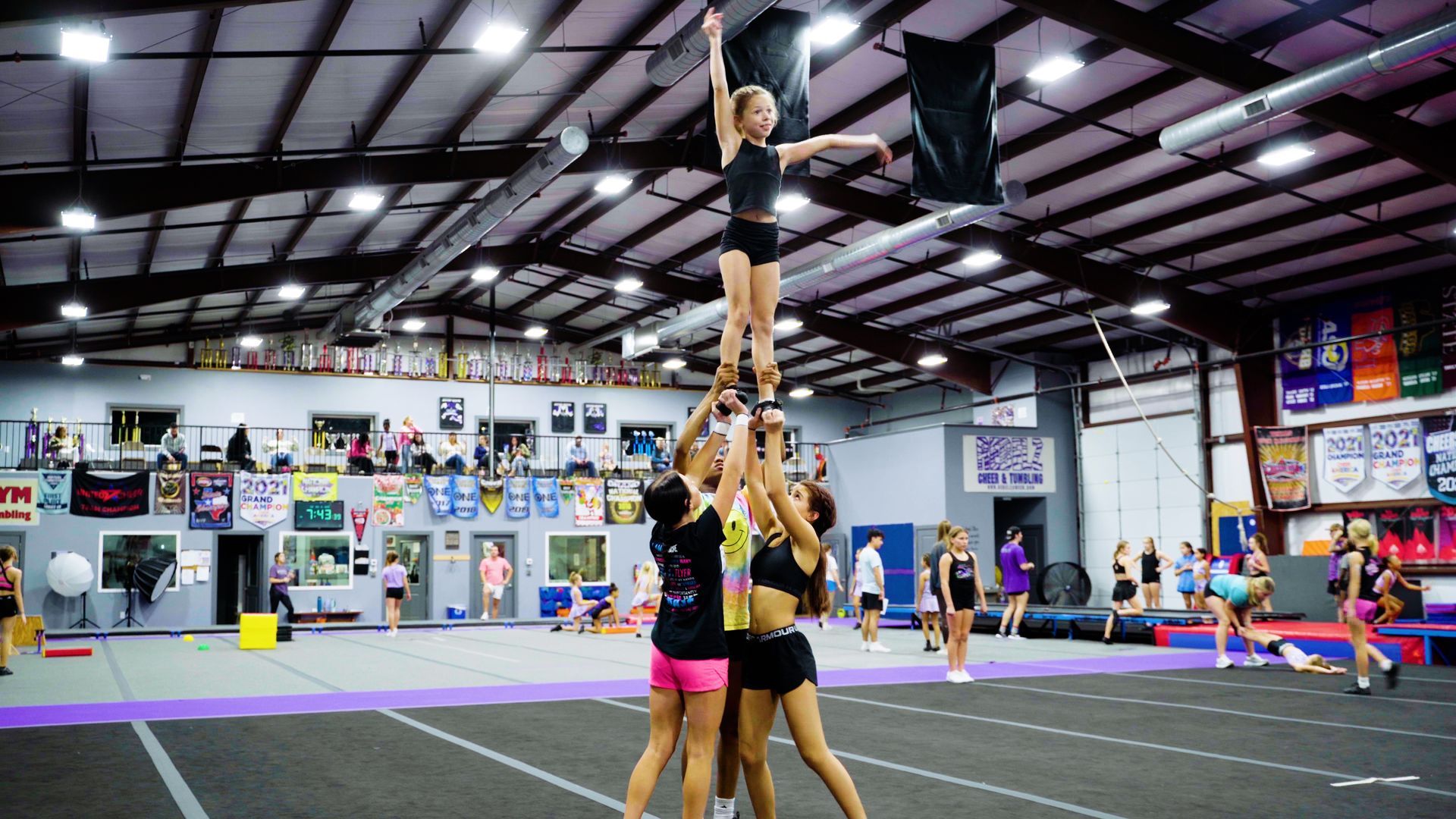 A group of cheerleaders are practicing in a gym.