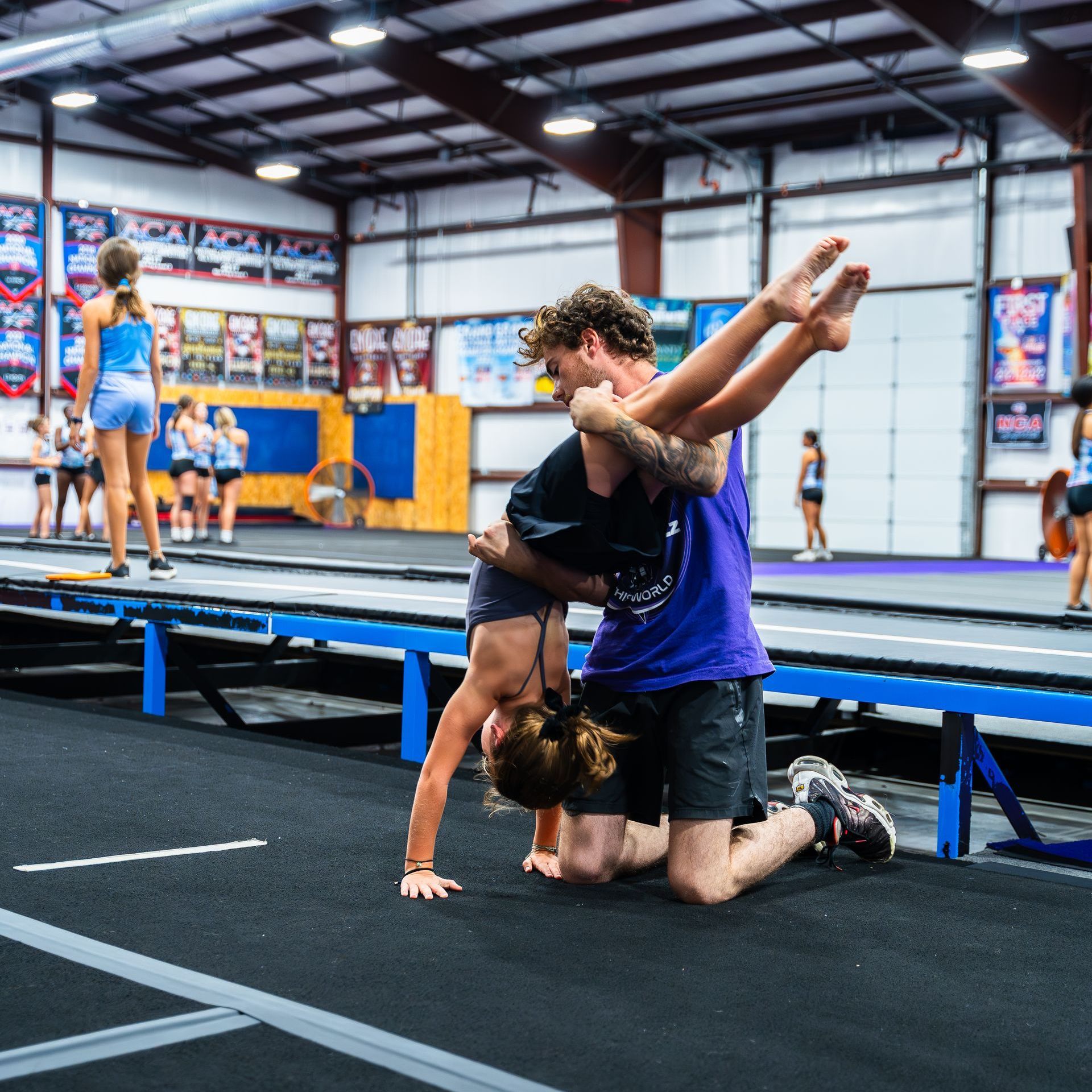 A man and a woman are doing a handstand in a gym