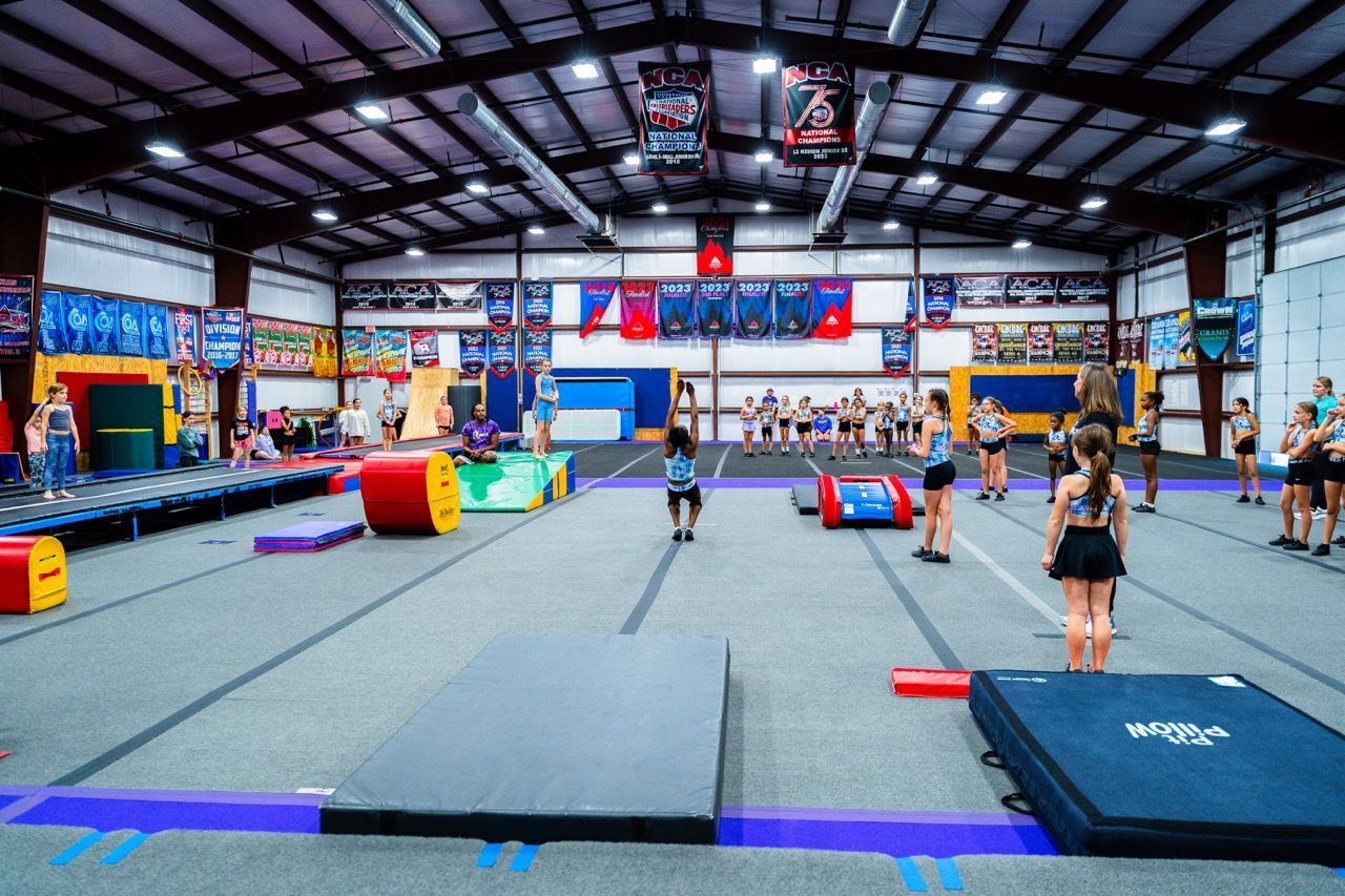 A group of girls are practicing gymnastics in a gym.