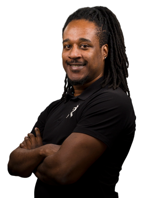 A man with dreadlocks is smiling with his arms crossed