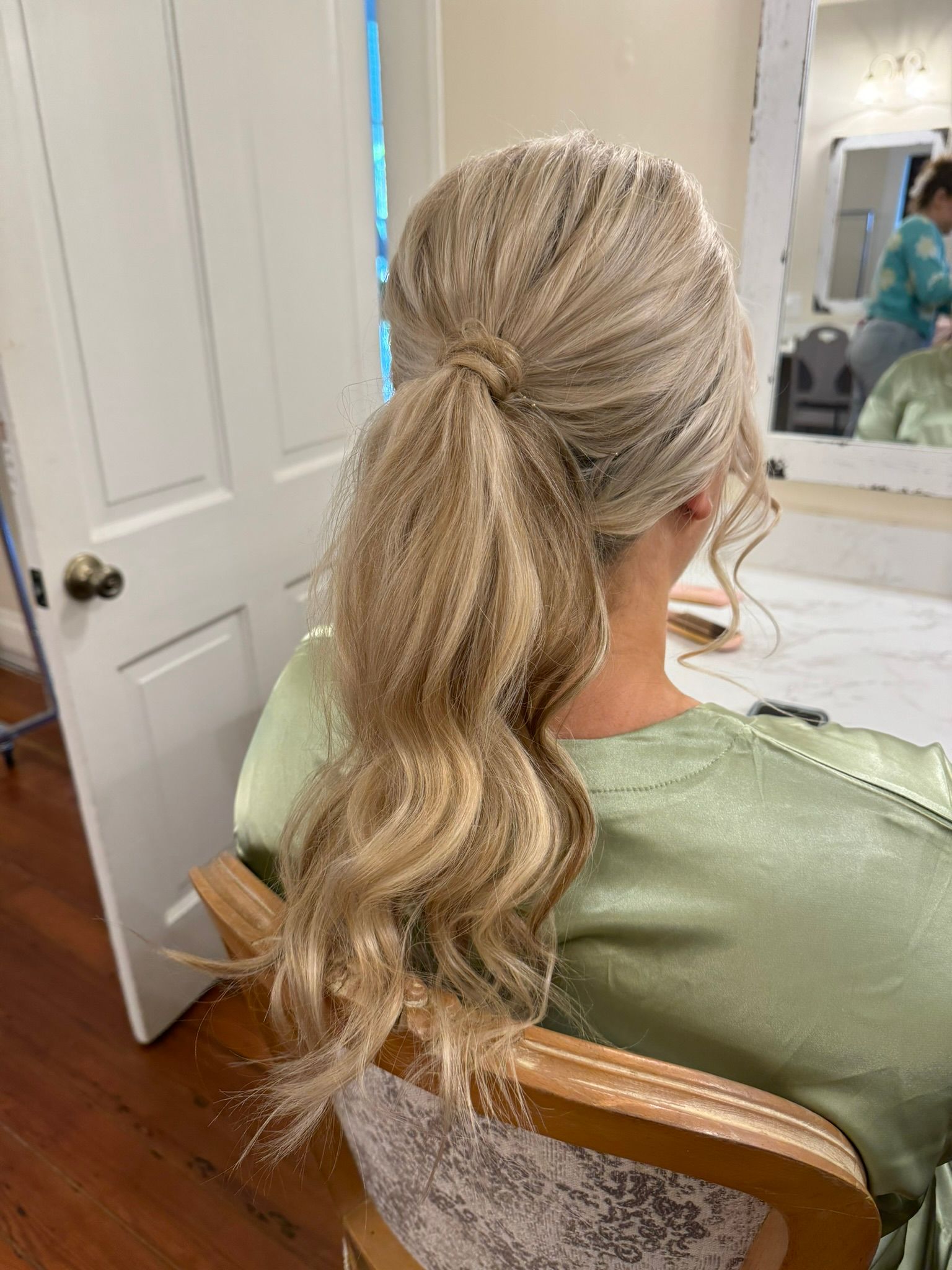 A woman is sitting in a chair with her hair in a ponytail