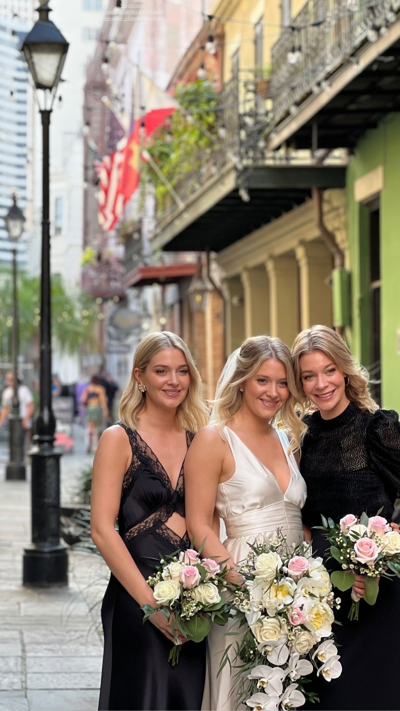 A bride and her bridesmaids are posing for a picture on a city street