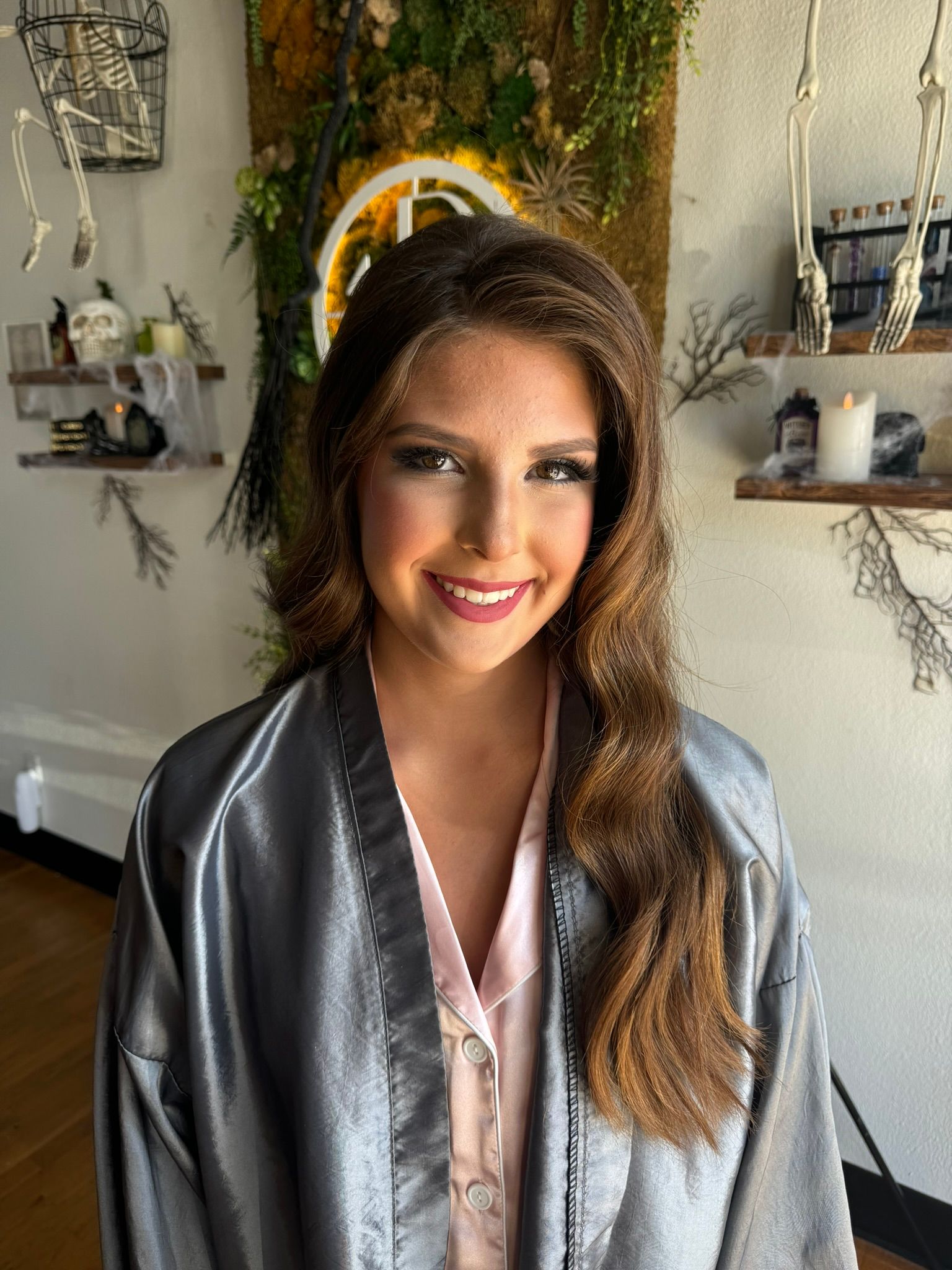 A woman in a gray robe is smiling in a room