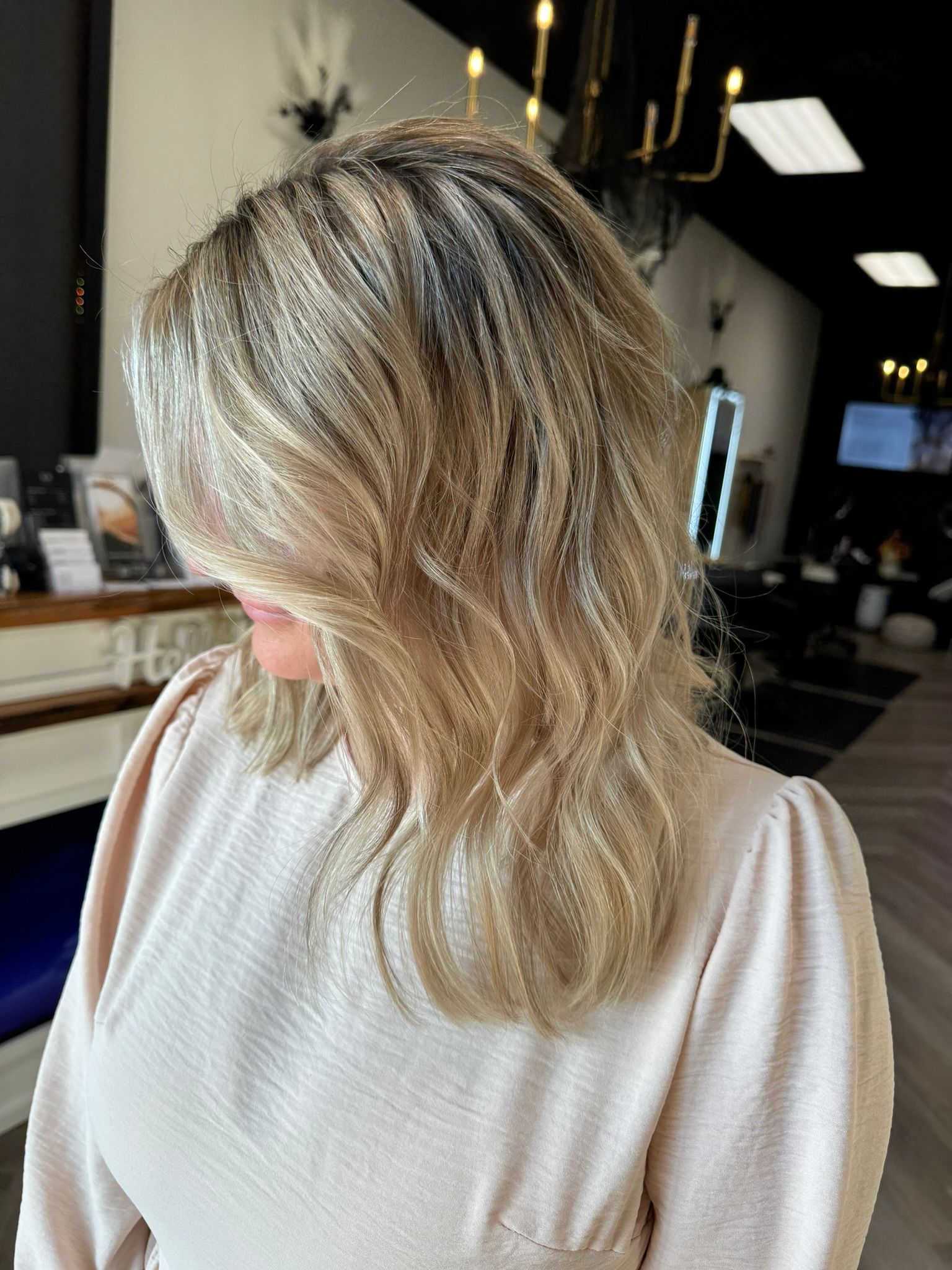 A woman with blonde hair is standing in a salon
