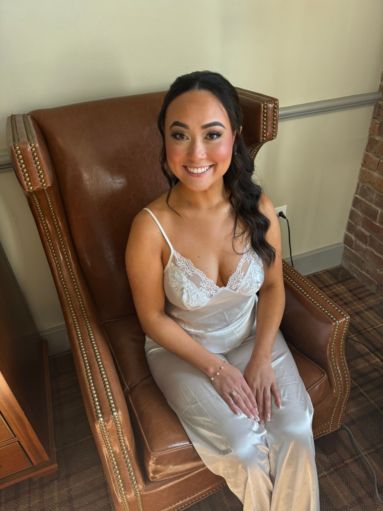 A woman in a white dress is sitting in a chair