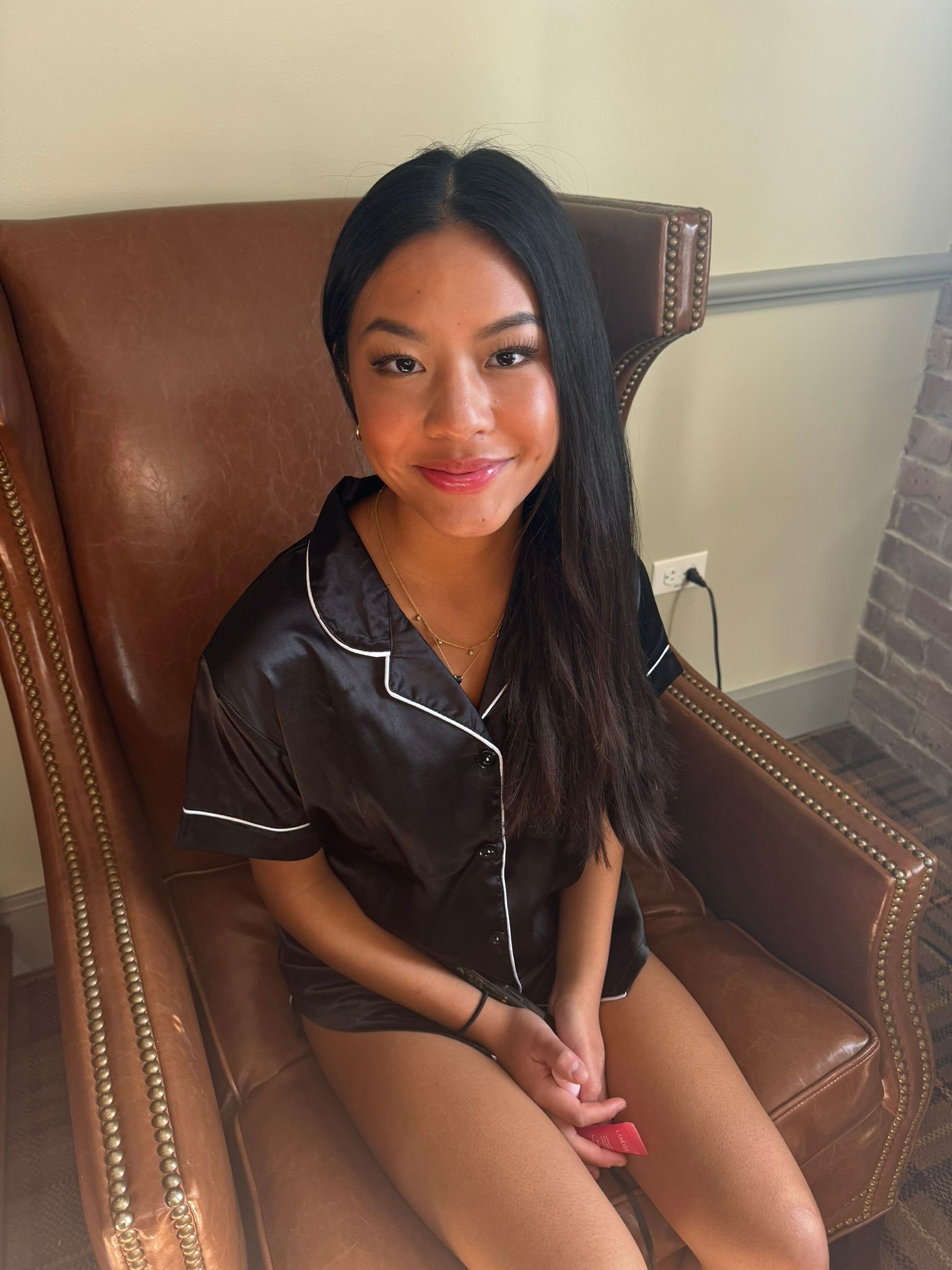 A young woman is sitting in a chair with her legs crossed