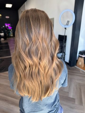 Woman with wavy blonde hair, ombre effect. Standing in a hair salon.
